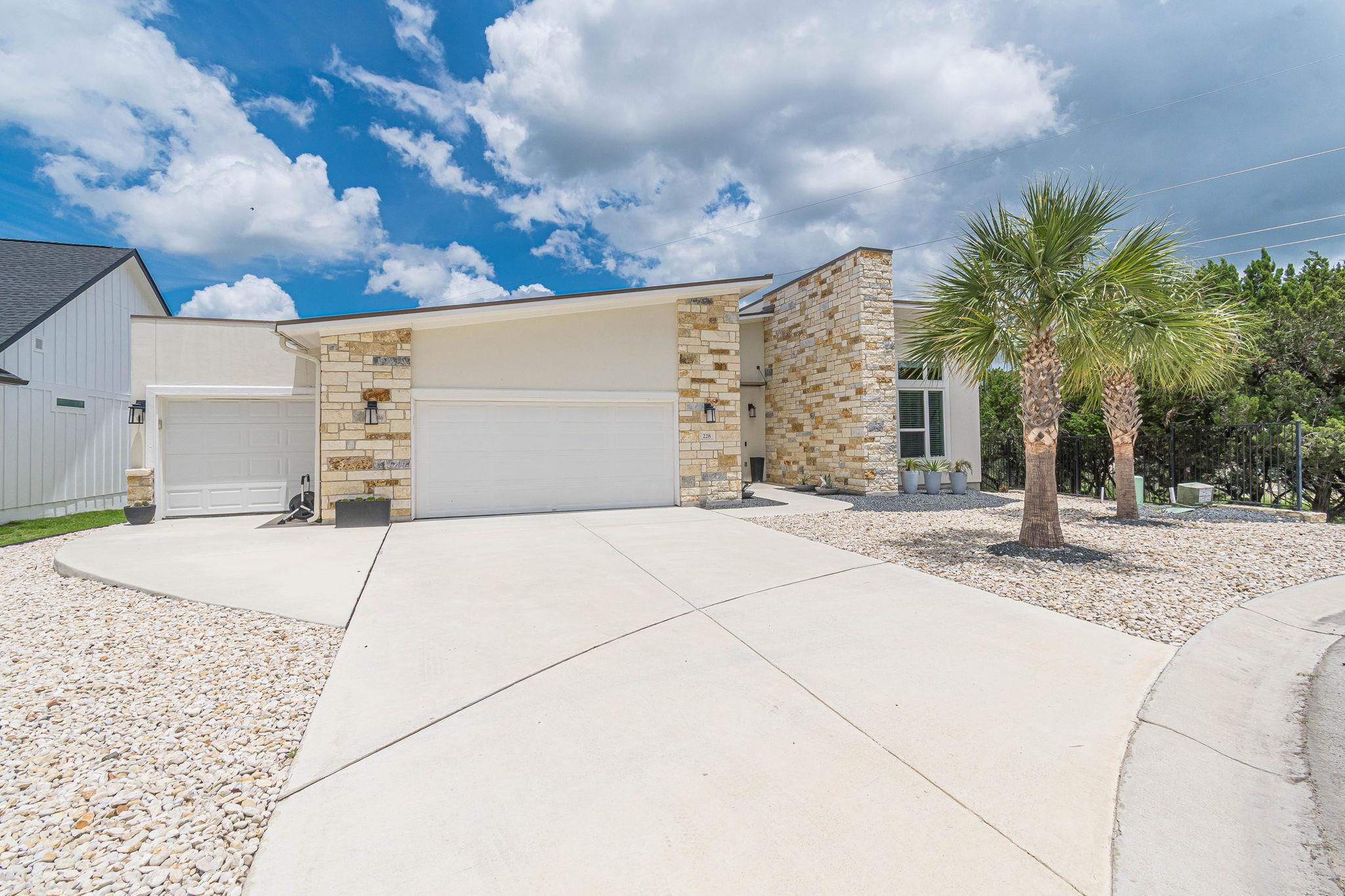 Modern stone and stucco exterior with multiple ga