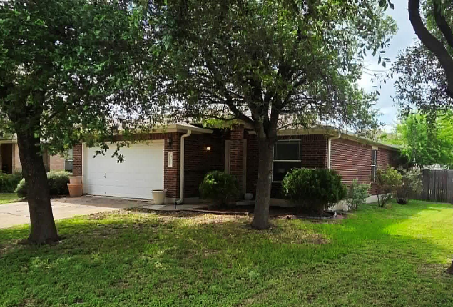 Mature trees shade this charming brick home with 