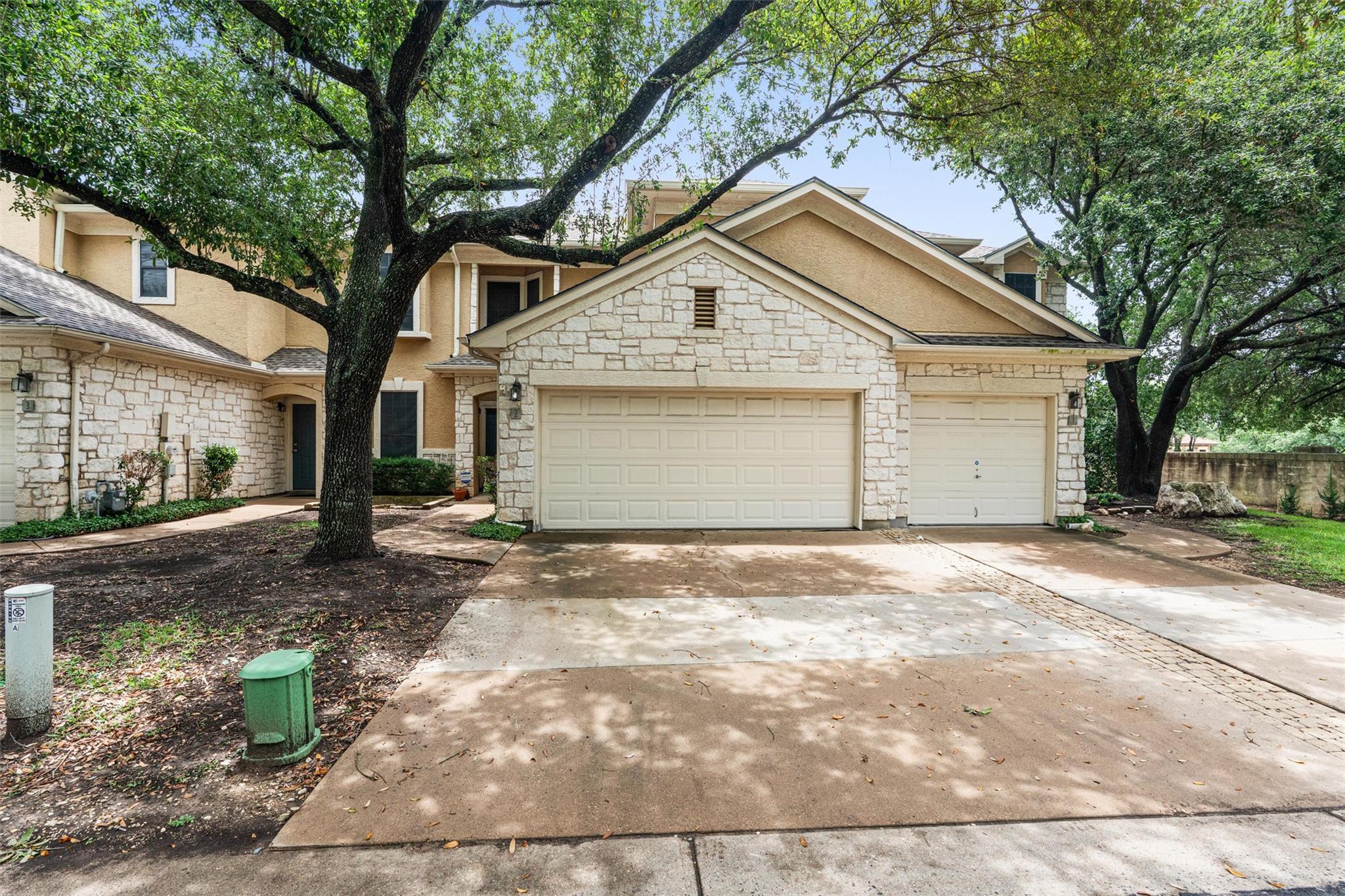 Stone facade and dual garages frame this charming