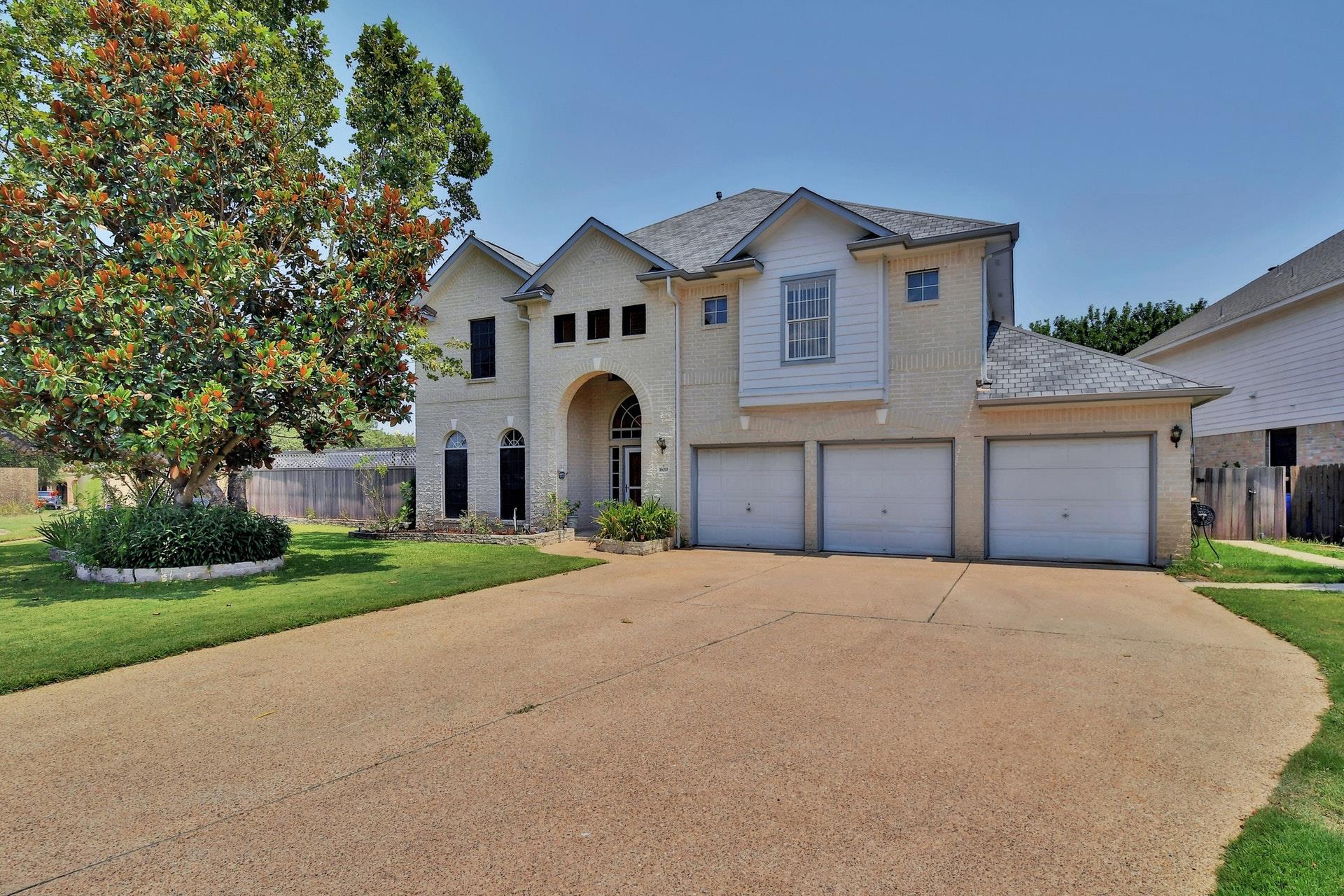 A classic brick exterior with a lush, well-kept l