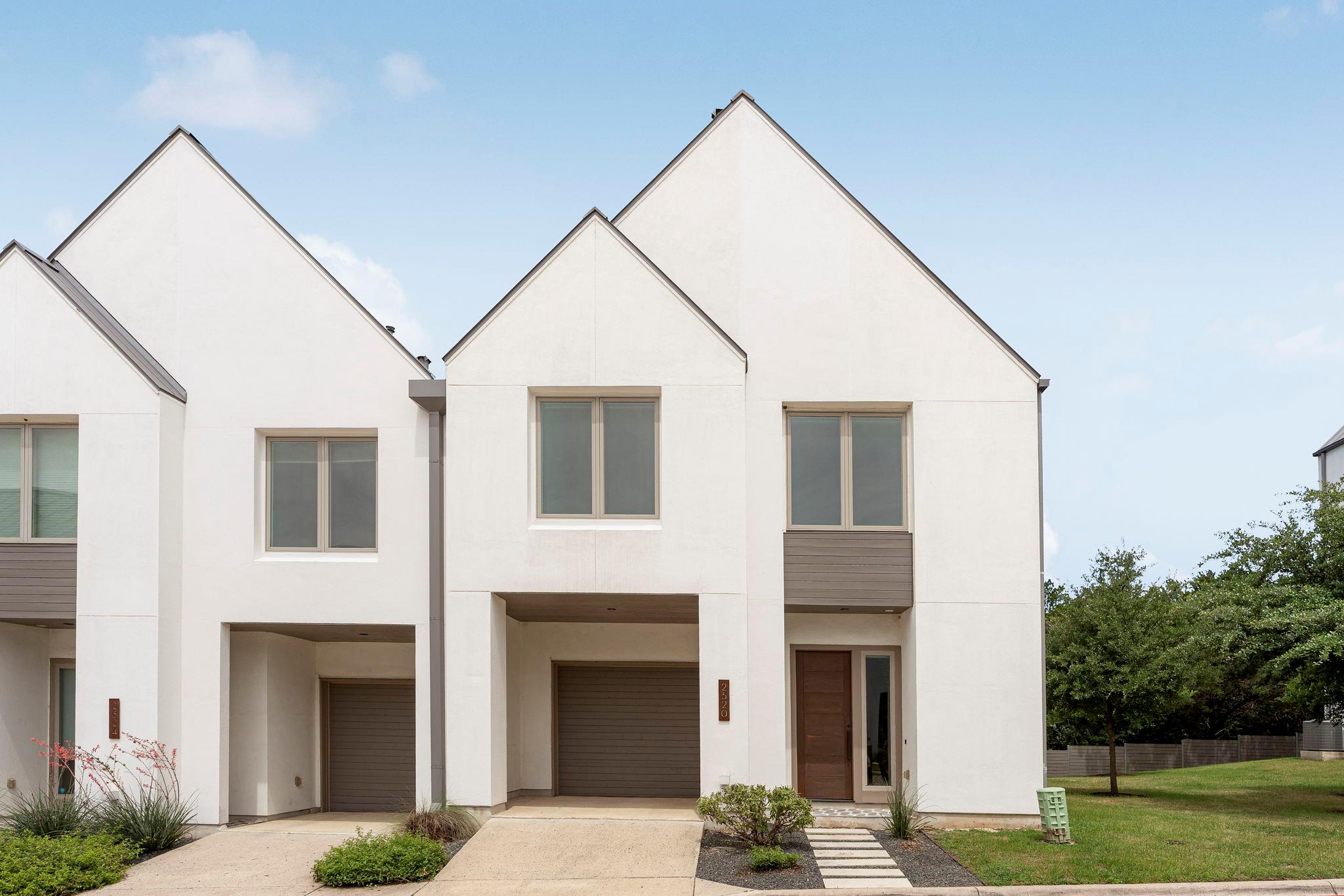 Modern townhome showcases a crisp white facade wi