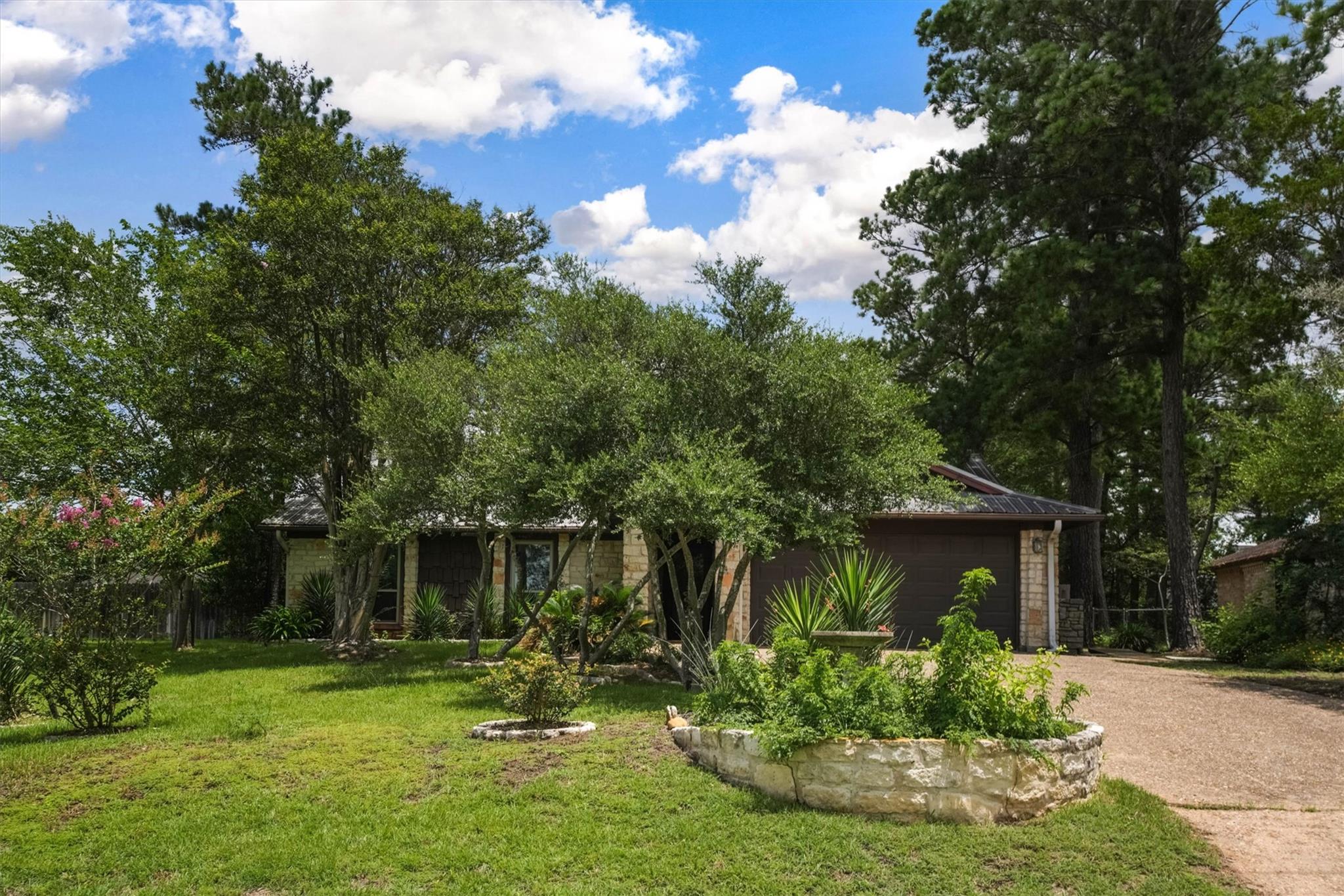 Mature trees and lush landscaping enhance the cur