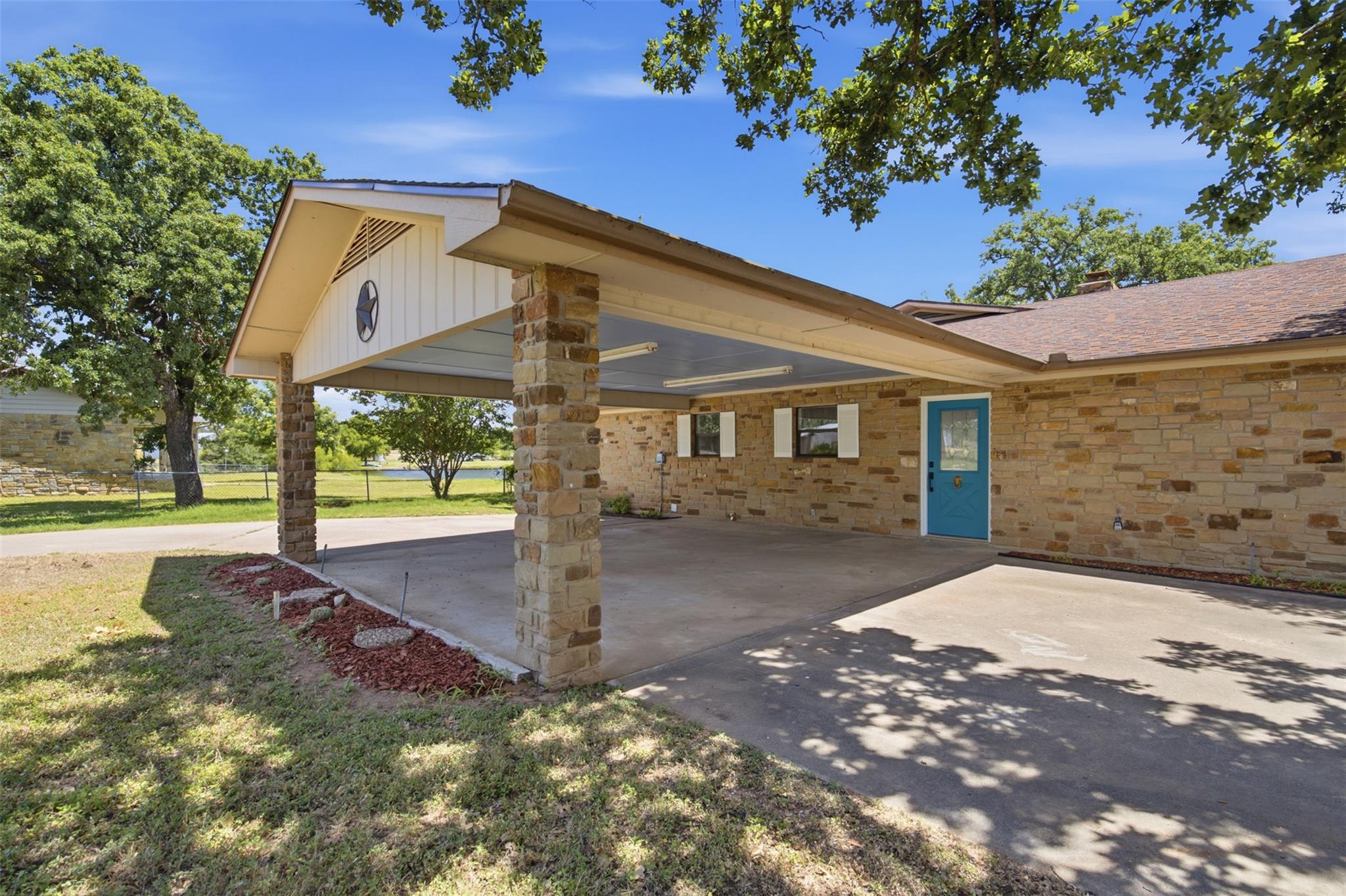 A charming stone facade home with a spacious carp