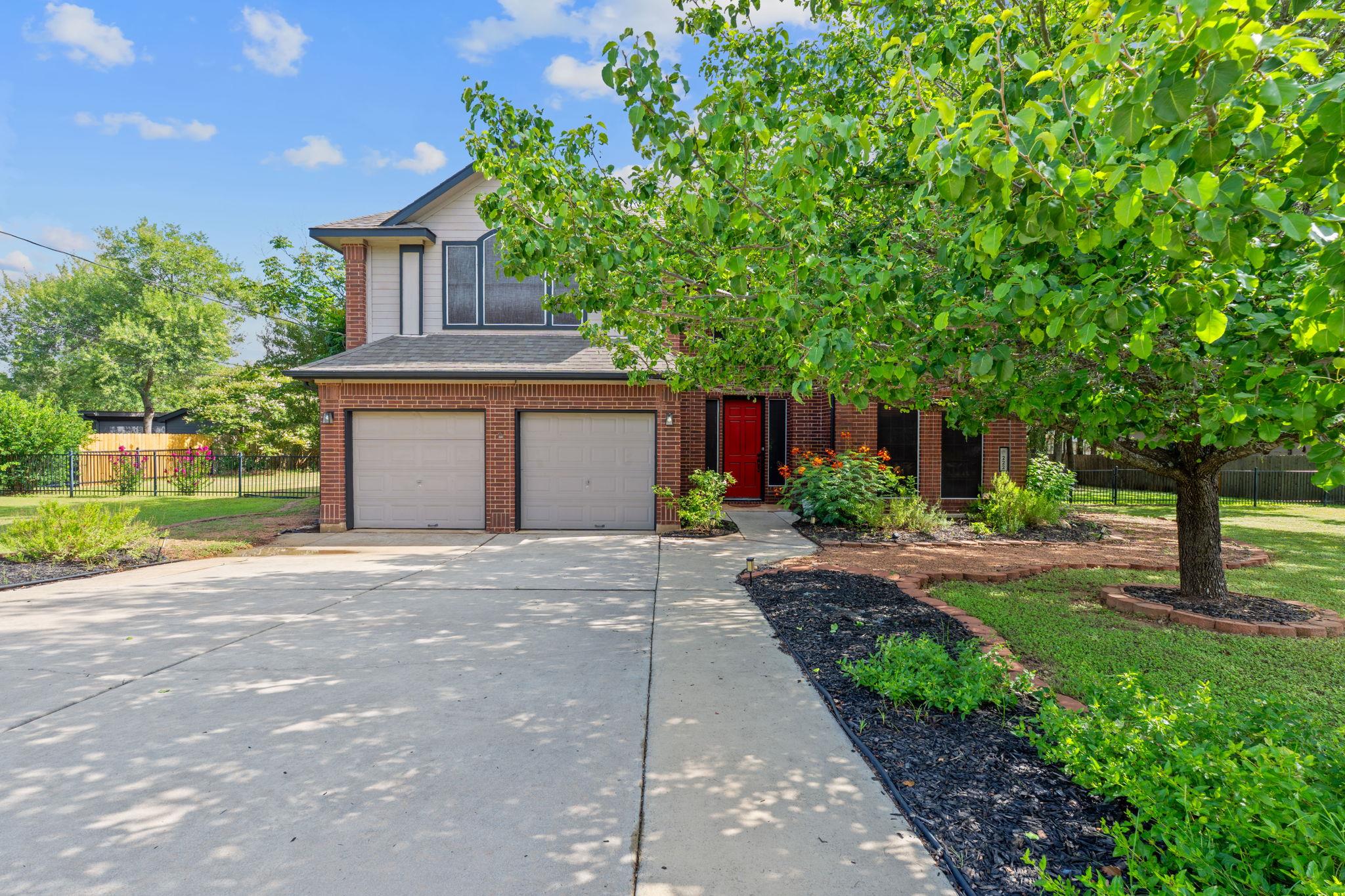 A classic brick-front home featuring a two-car ga