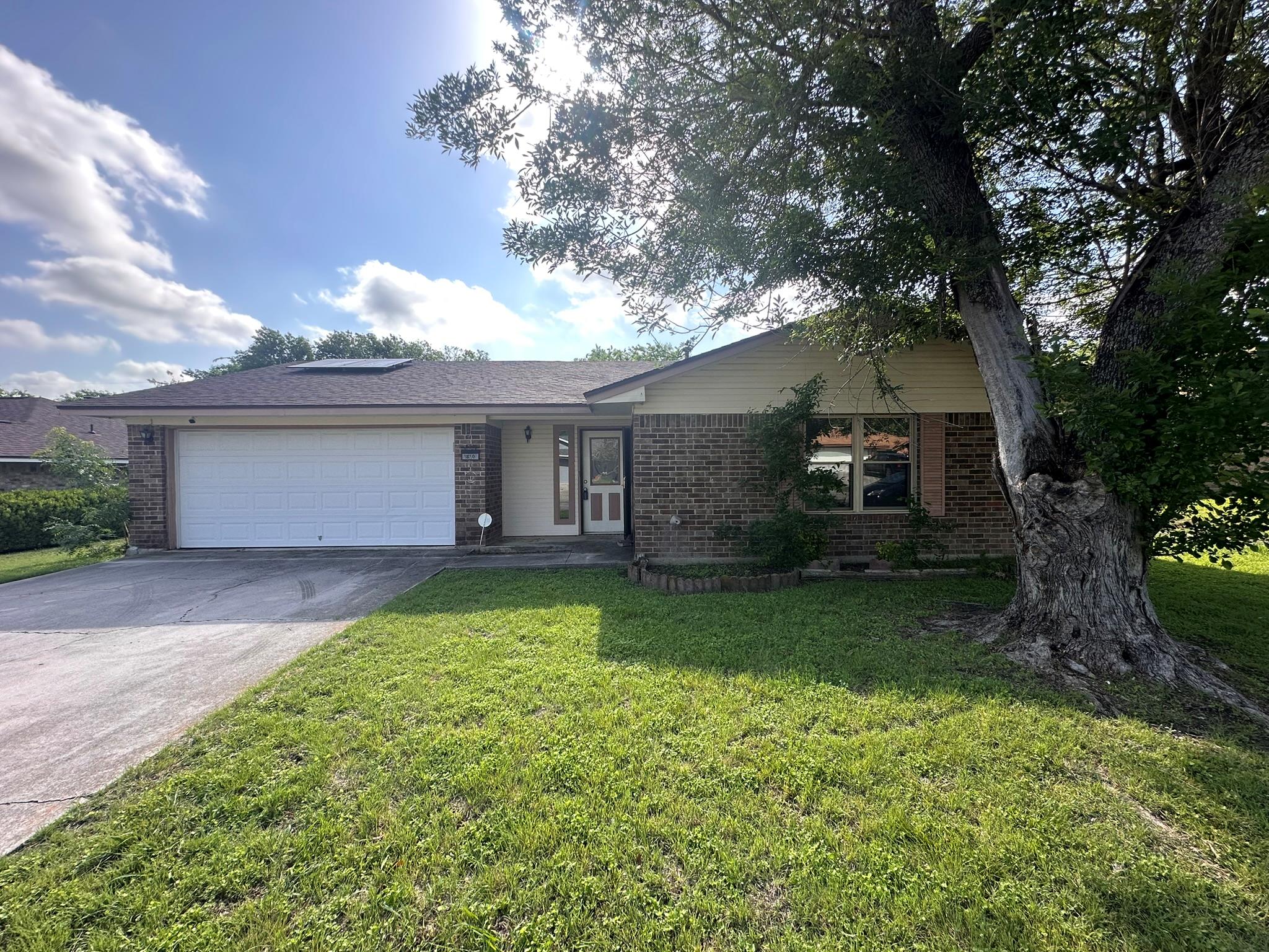 A classic brick-front home with an attached garag