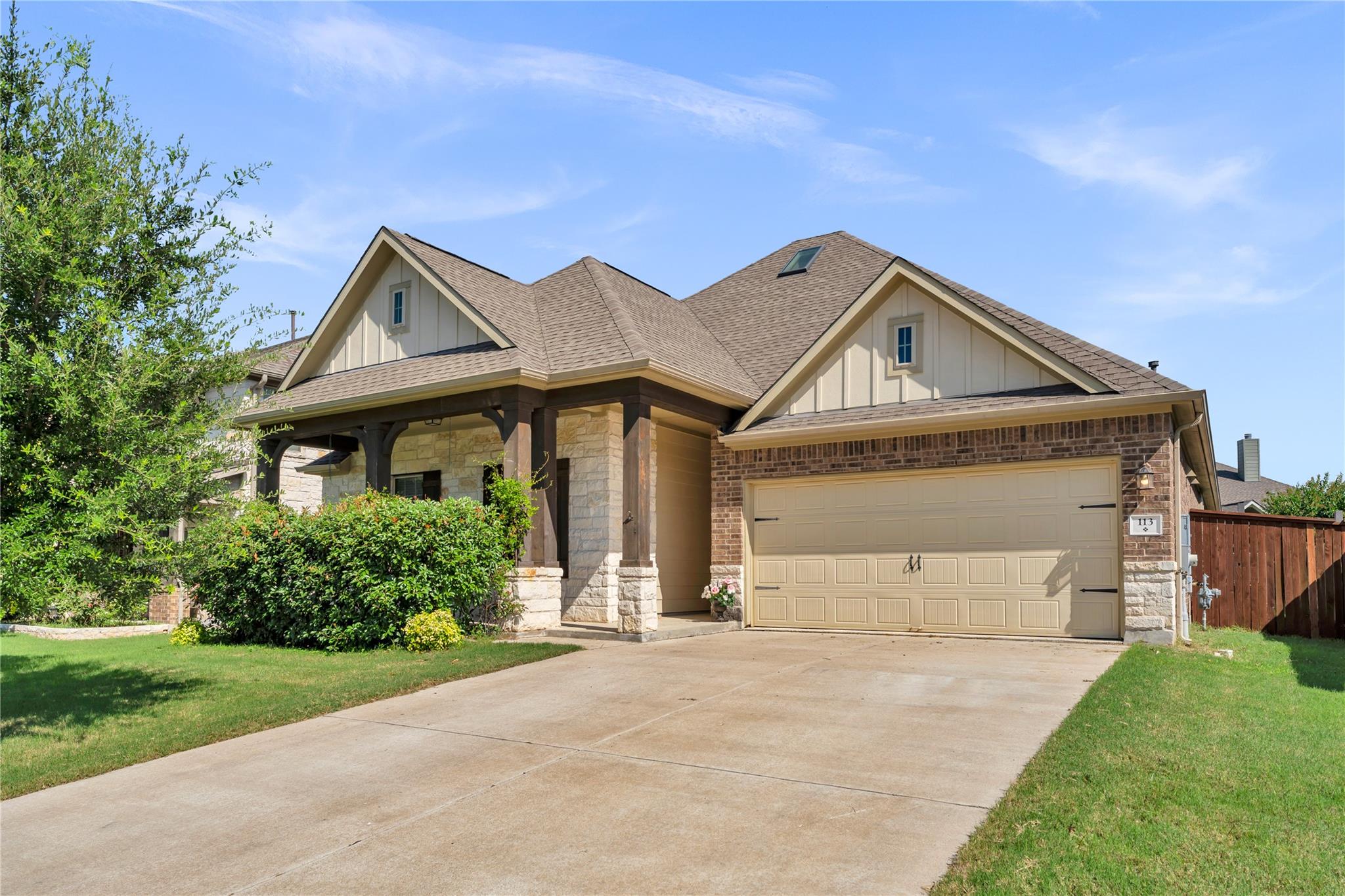 A welcoming brick and stone facade home, featurin