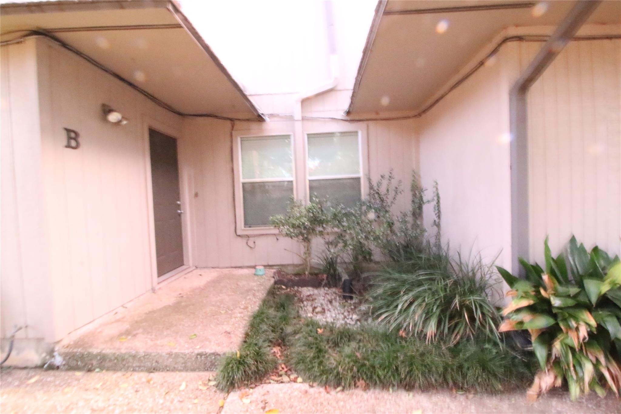 A welcoming front entrance featuring mature lands