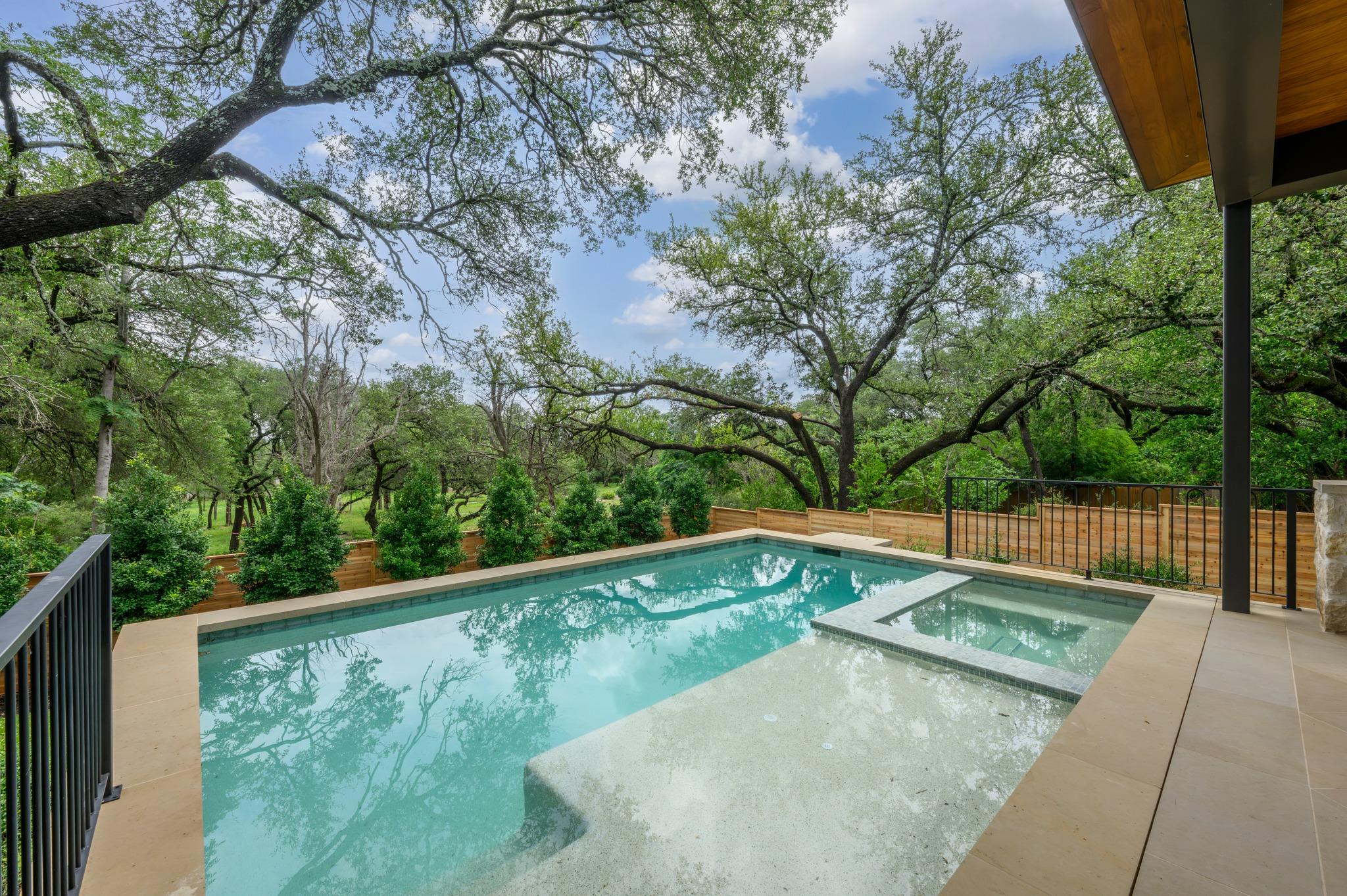 An inviting outdoor pool with integrated spa and 