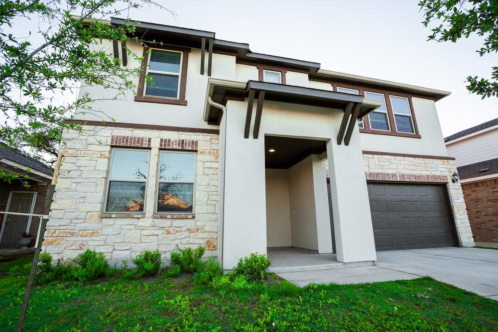 A contemporary façade blends stucco and stone, pr