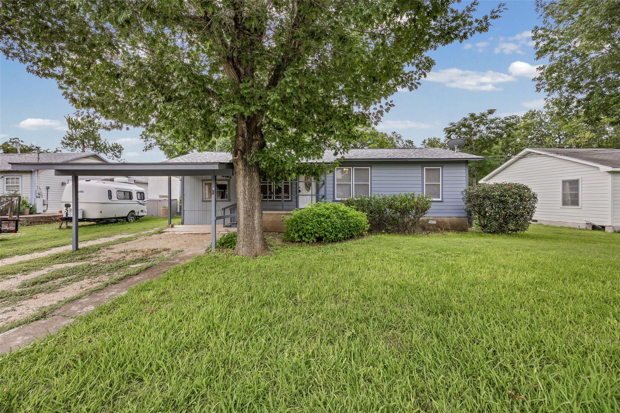 A welcoming front yard with a mature shade tree g