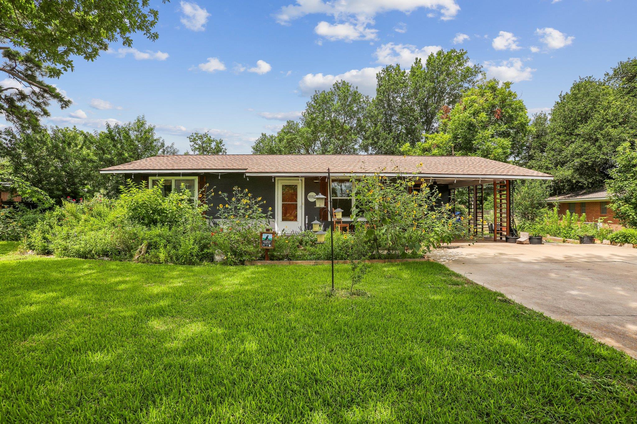 A welcoming front exterior with mature landscapin
