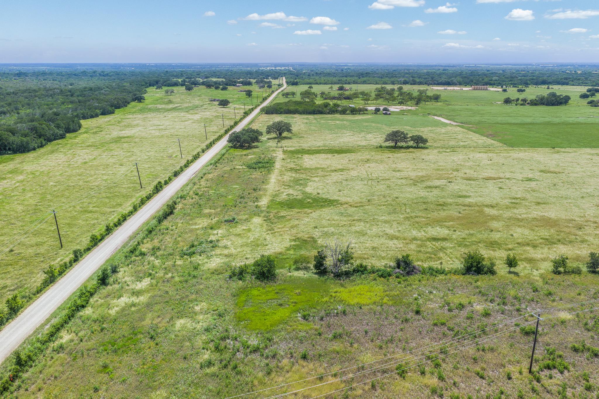 Vast green acreage featuring a long, private road