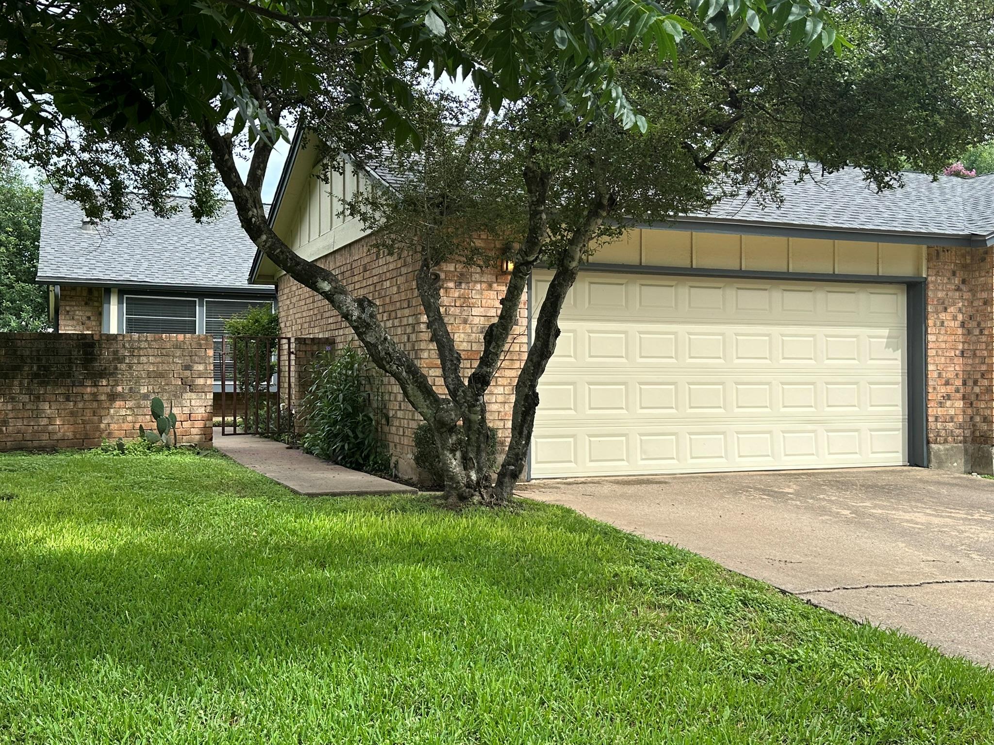 Mature trees and neat landscaping frame this attr