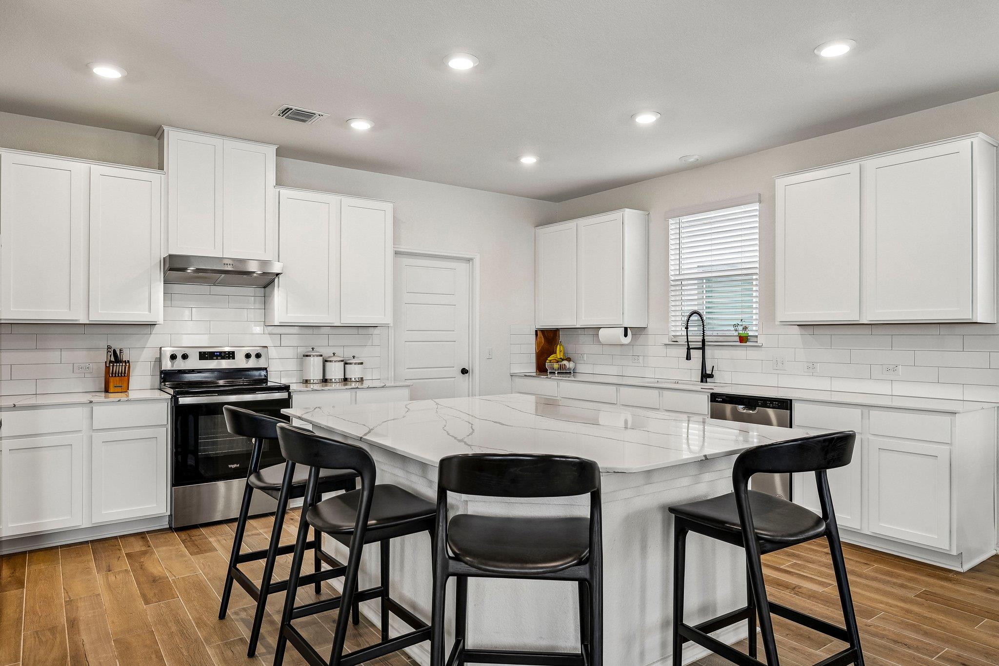 White cabinetry and subway tile backsplash comple