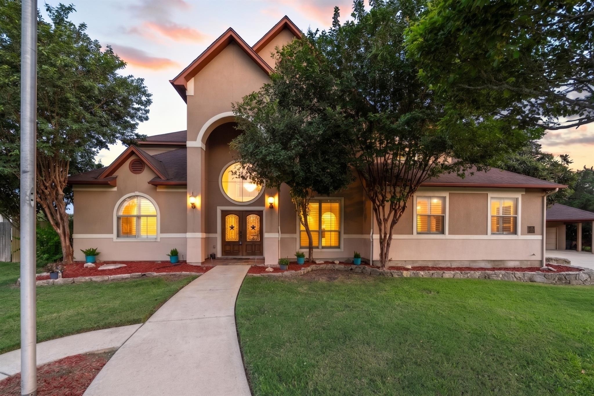 Grand arched entry and manicured landscaping welc