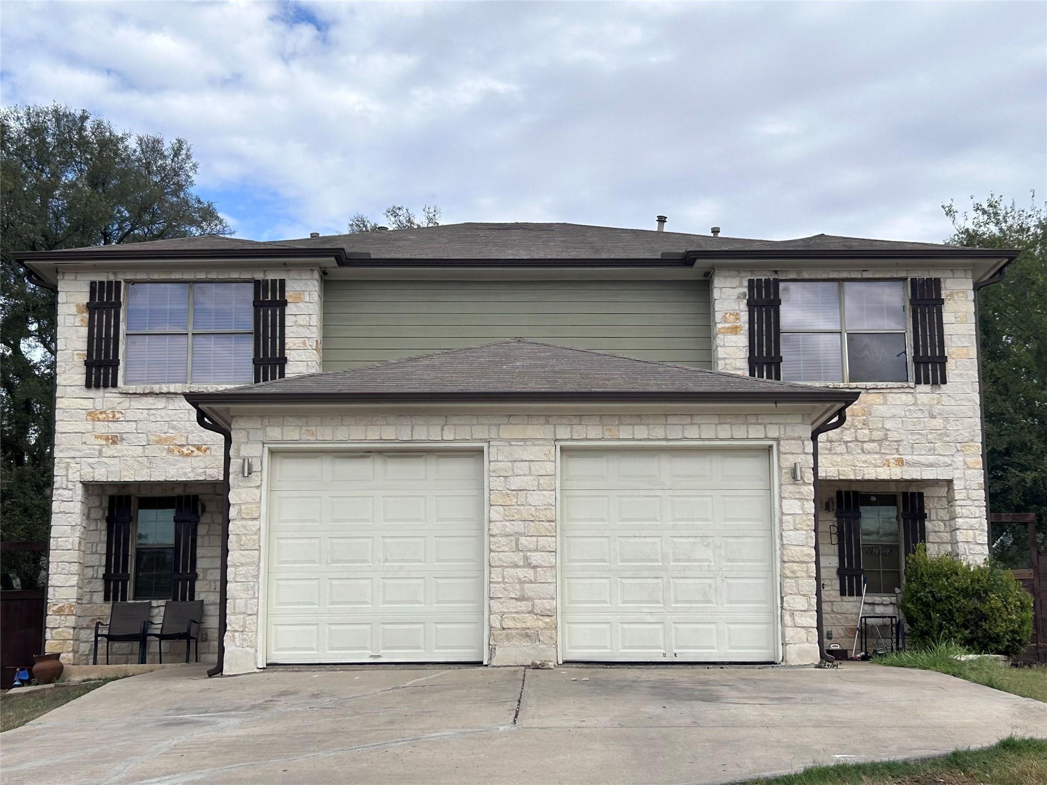 Traditional home with stone siding, concrete driv