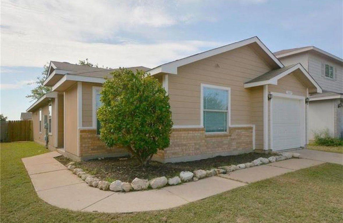 A classic ranch home features a neatly manicured 