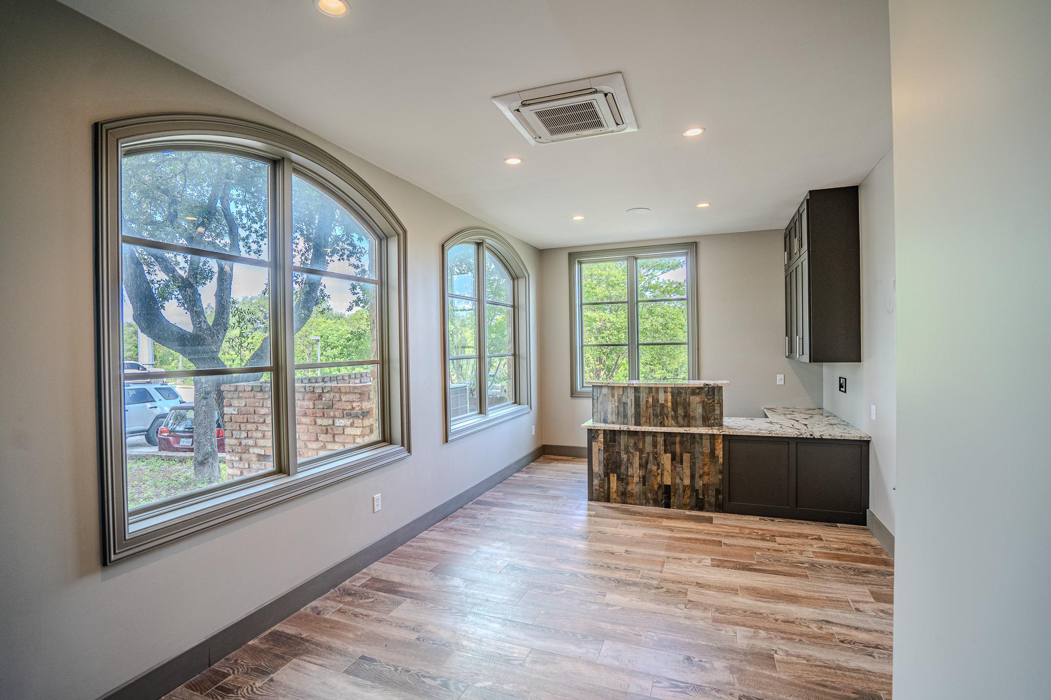Well-lit room features wood-look flooring and a f
