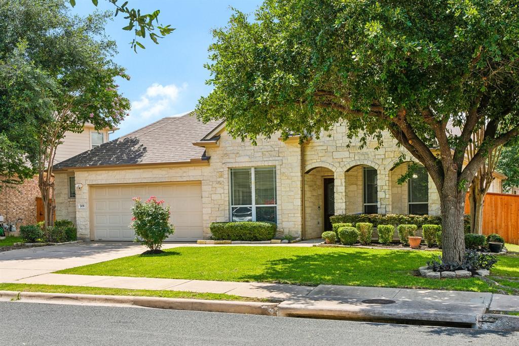 A cream stone facade and lush landscaping enhance