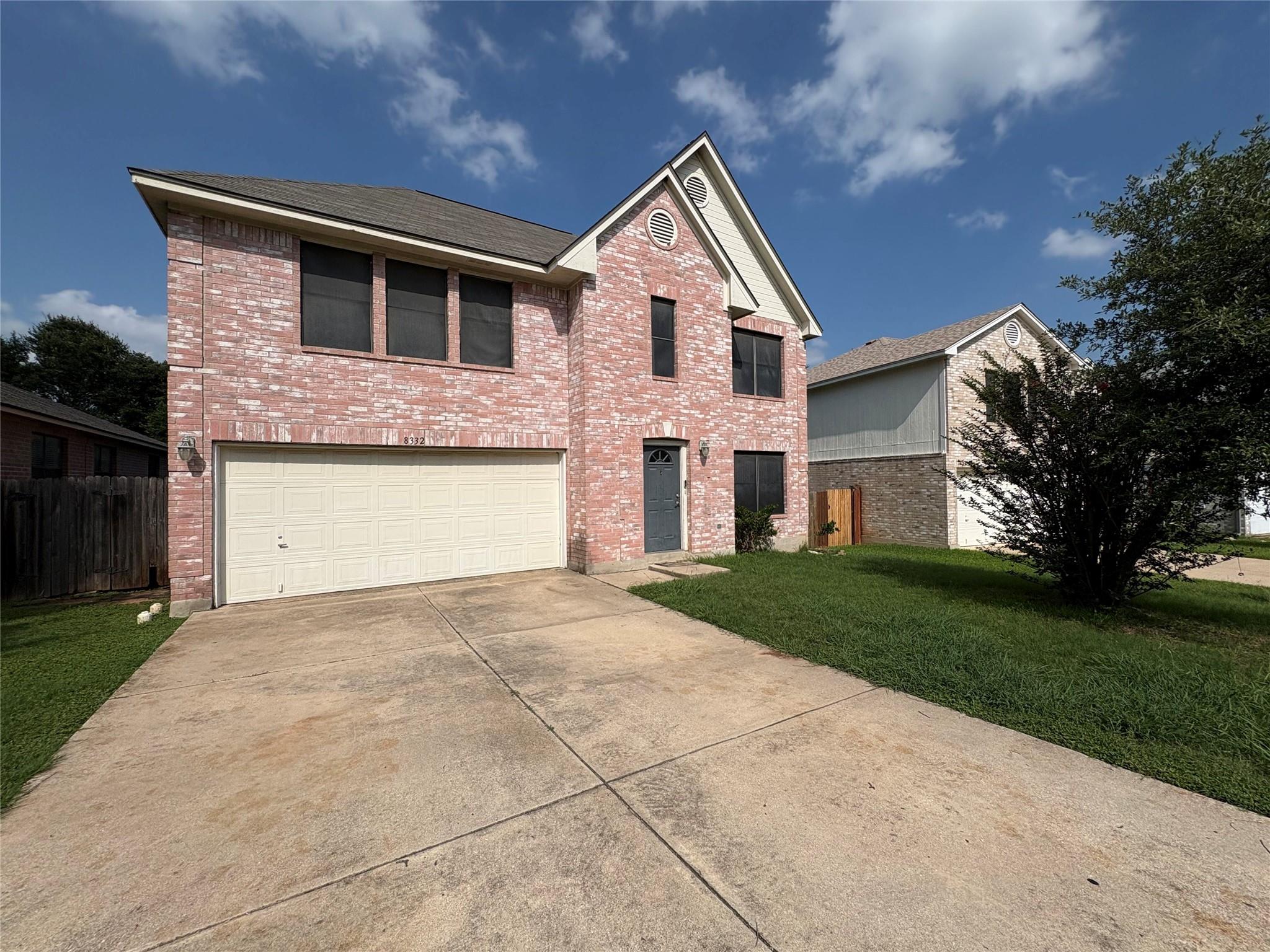 A classic brick exterior with a two-car garage aw