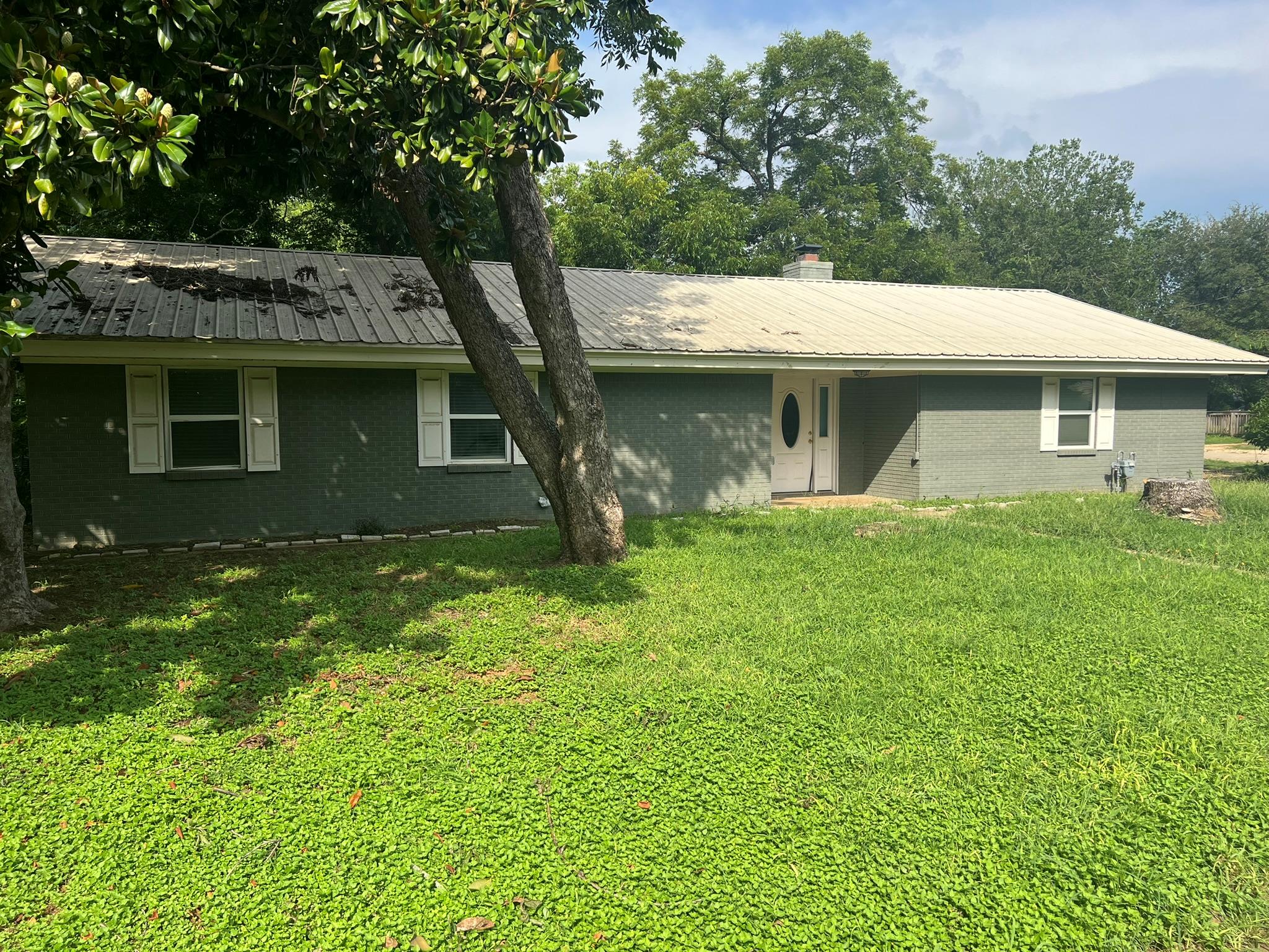 A classic brick exterior home with a metal roof a