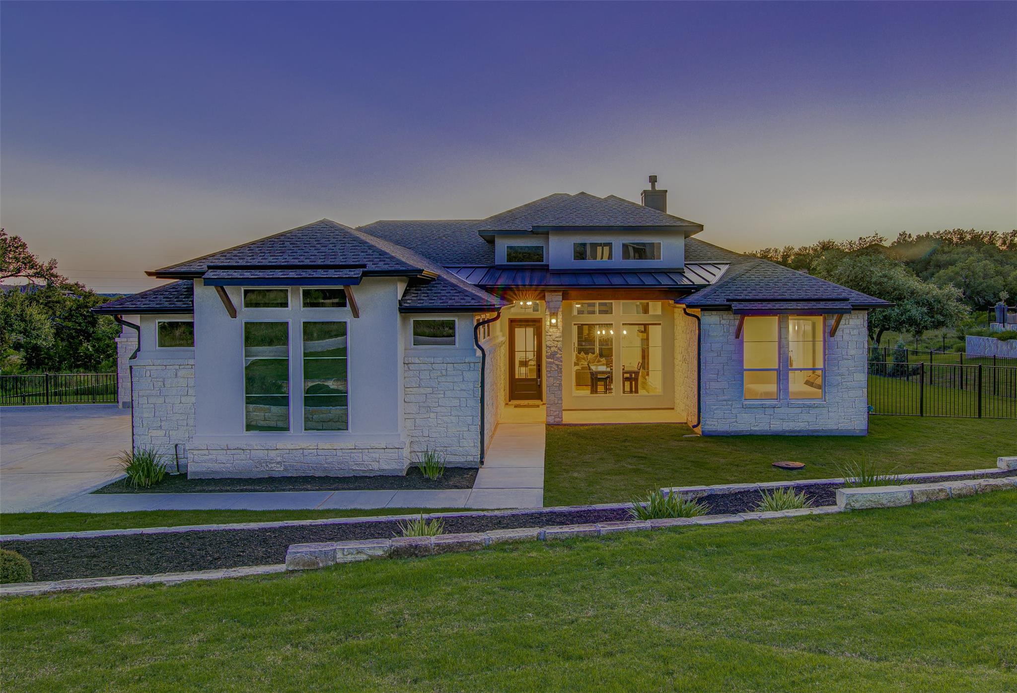 A well-maintained lawn and stone façade welcome v