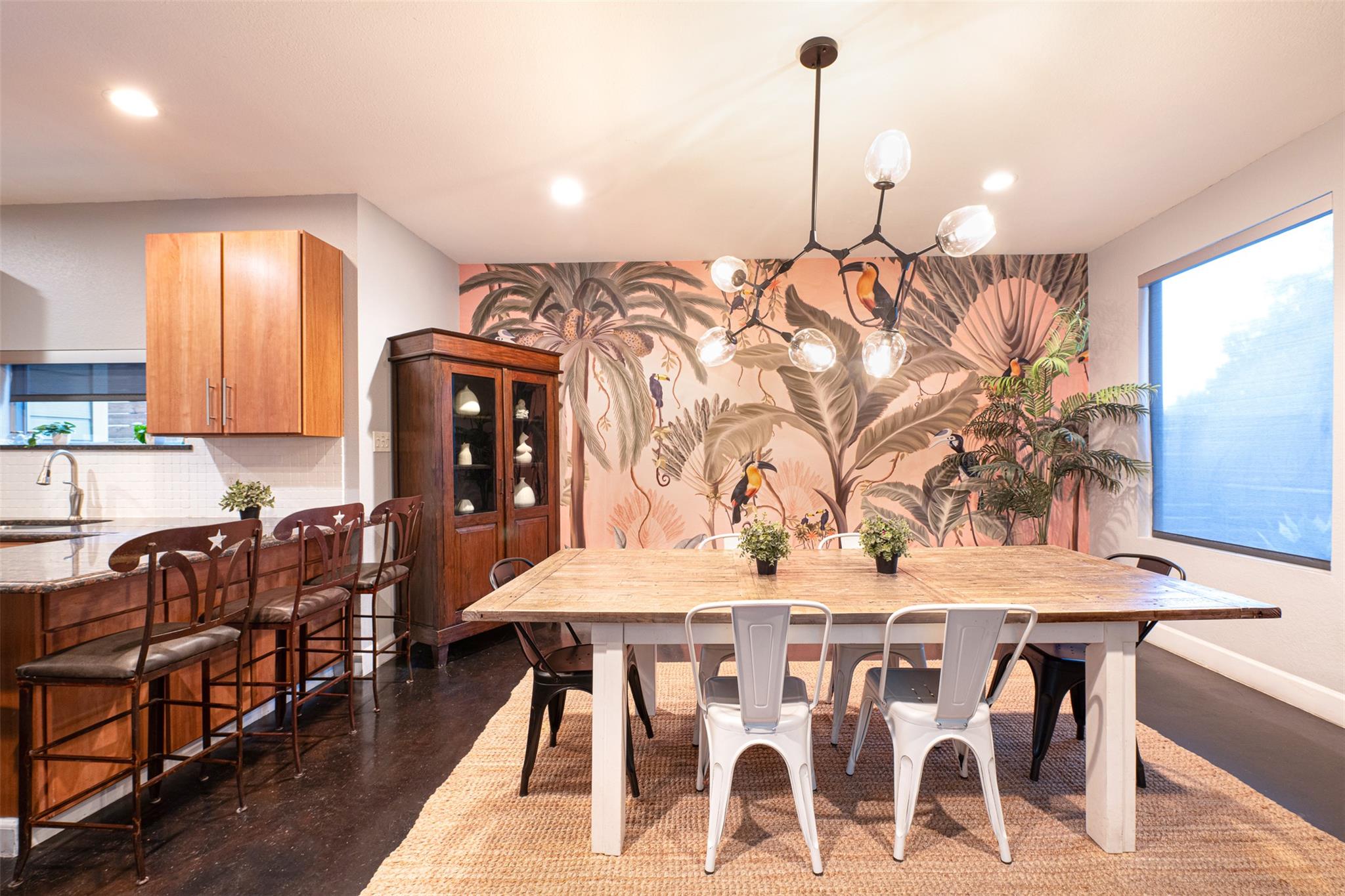 Bold tropical wallpaper enlivens this dining area
