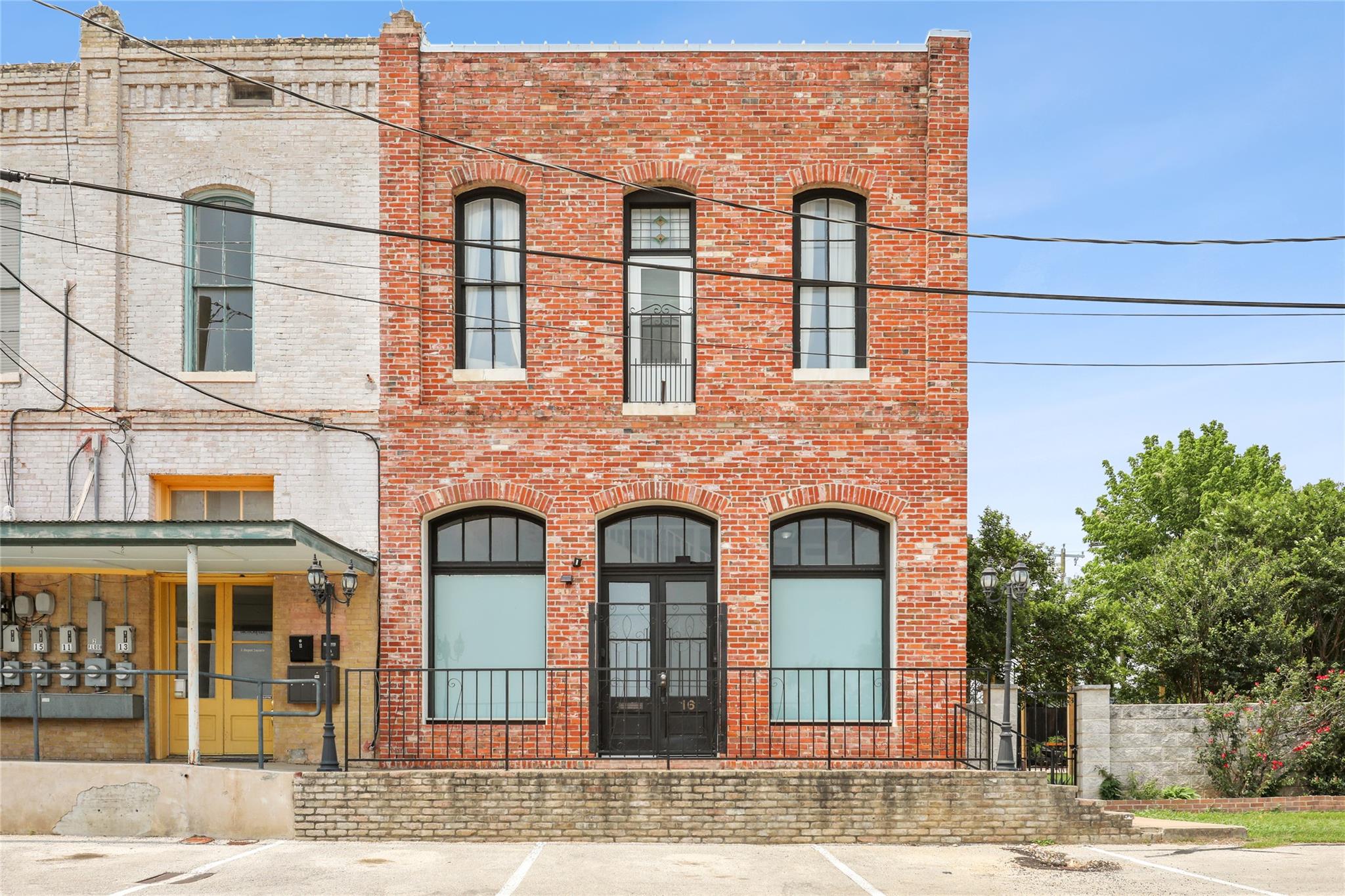 Historic brick facade with arched windows and iro