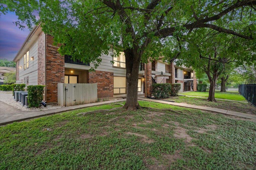 Mature trees and lush lawns enhance the brick and