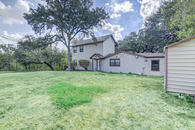 Mature trees shade a spacious lawn surrounding th