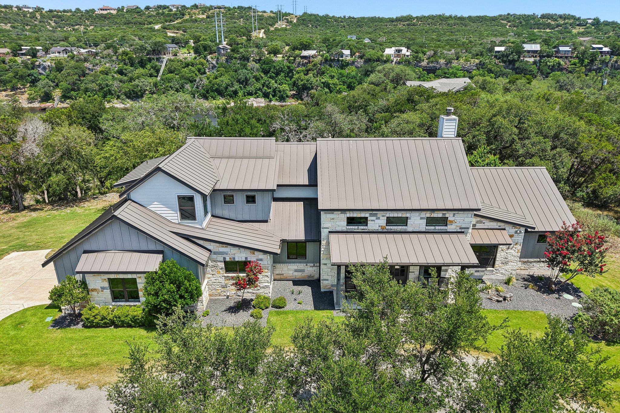 Perched on a verdant hillside, this modern reside