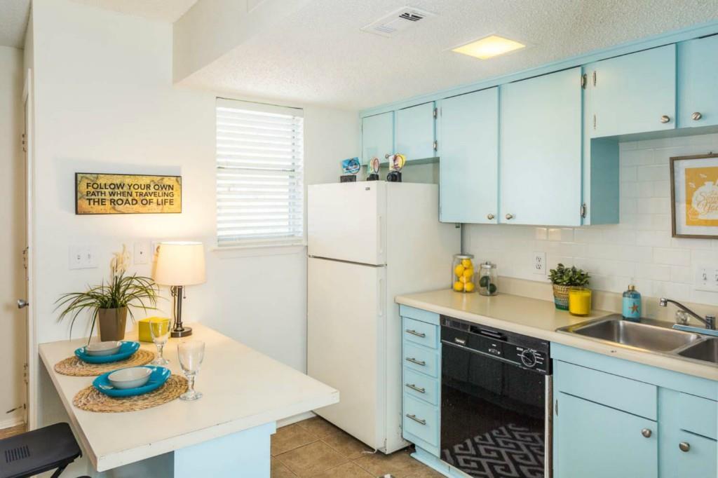 A compact kitchen with cheerful blue cabinetry of