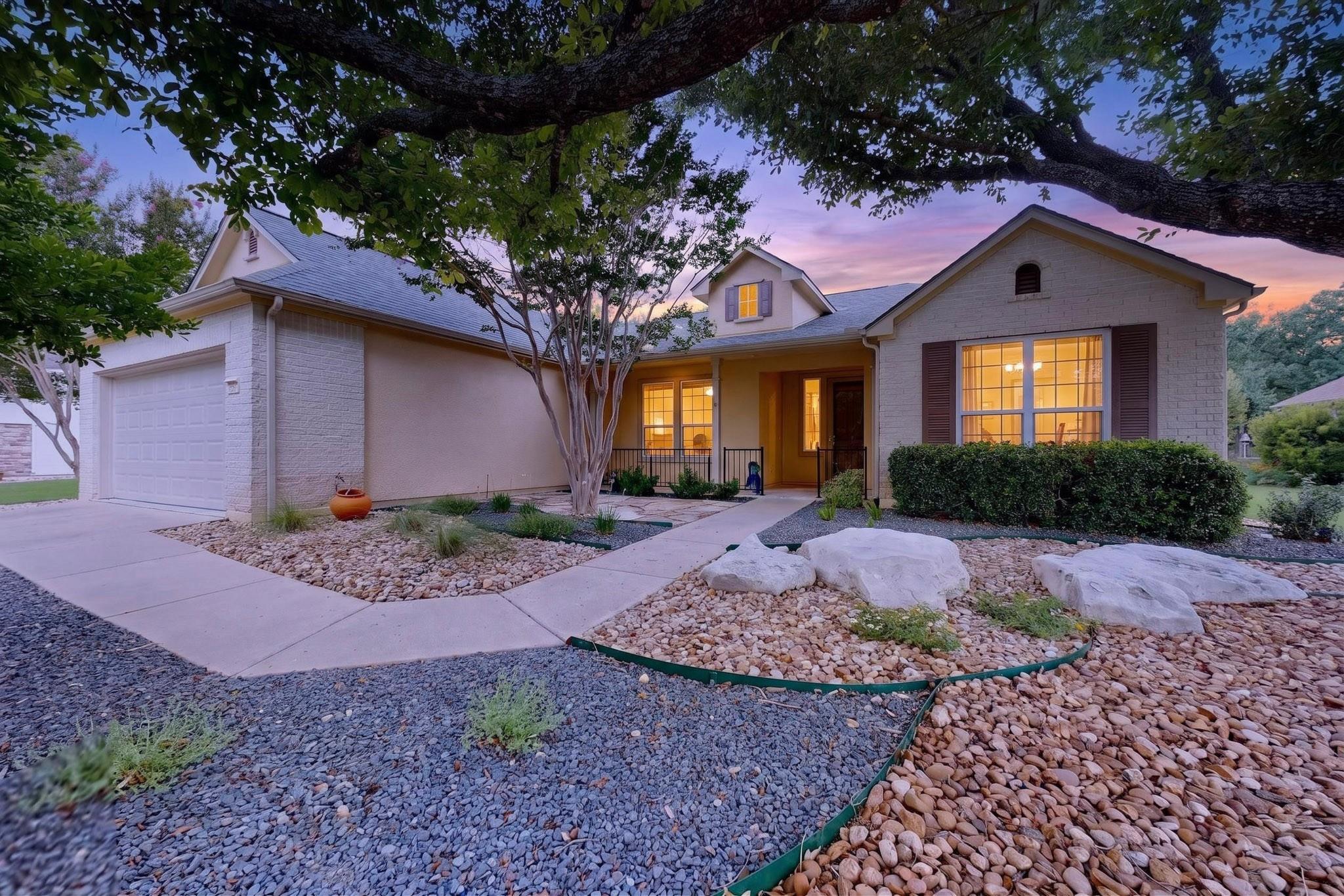 A welcoming facade with tasteful landscaping and 