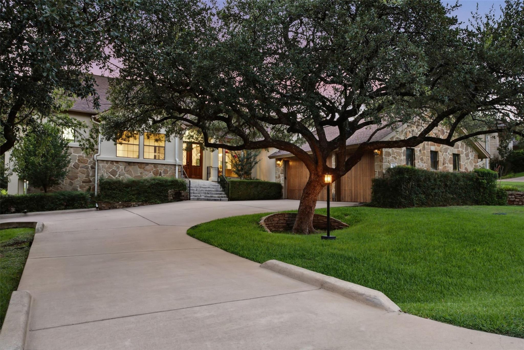 Mature trees frame a winding driveway leading to 