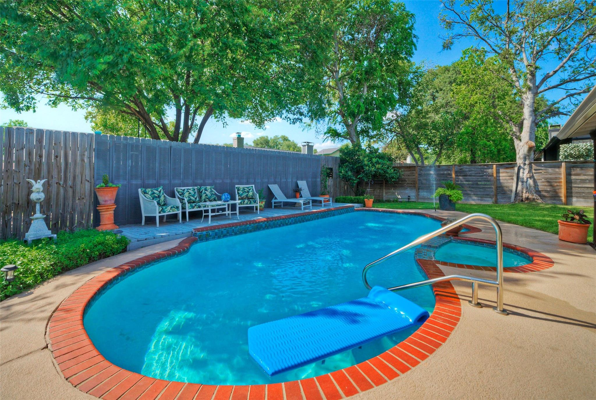 An inviting backyard oasis offers a sparkling poo