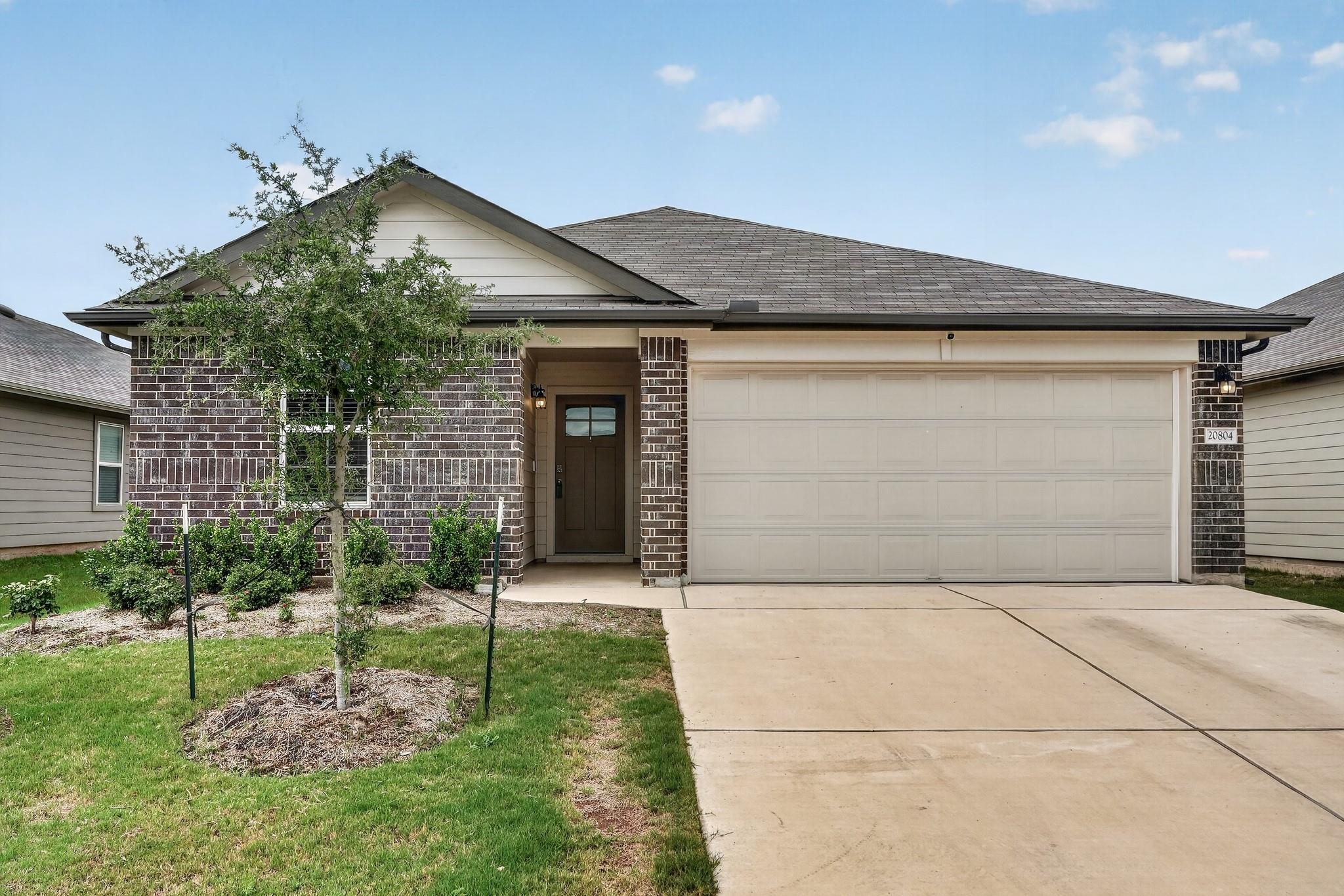 A welcoming brick exterior with an attached garag