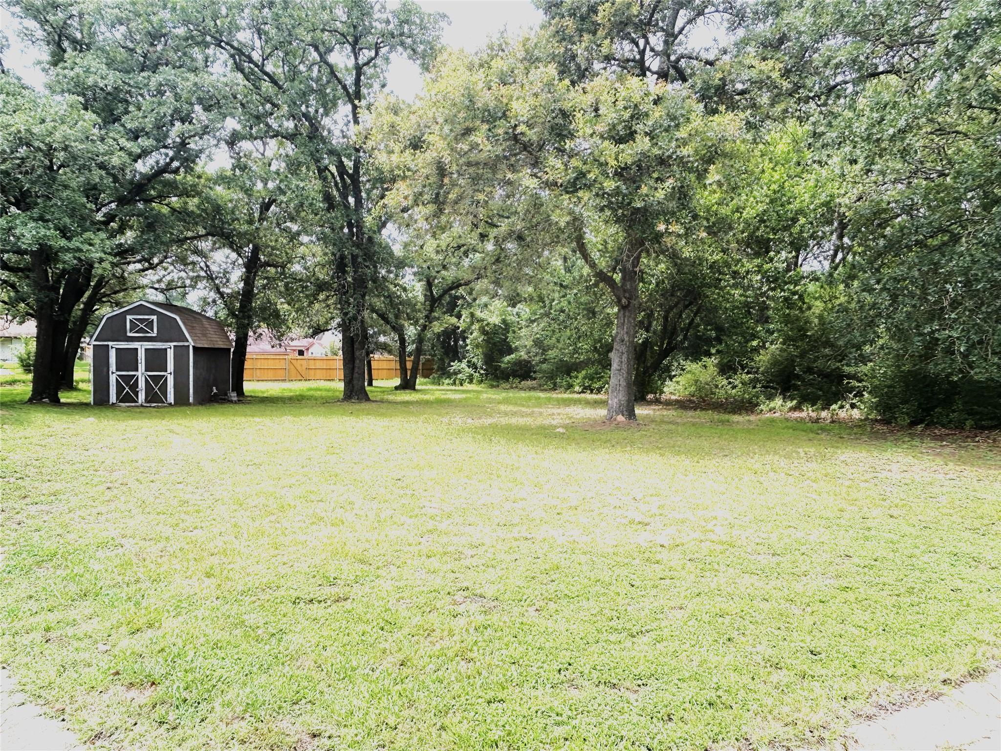 A spacious, verdant yard with mature trees and a 