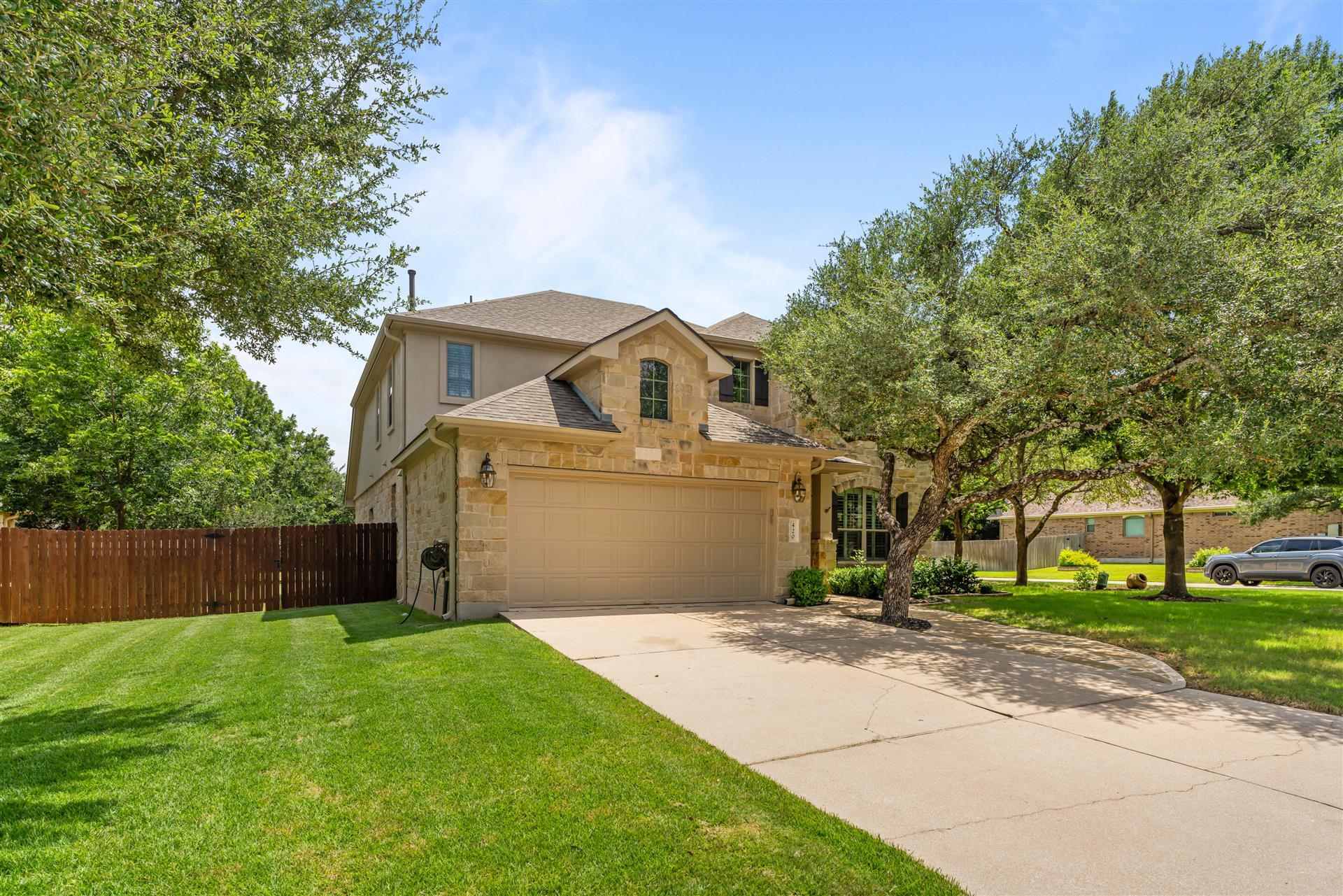 Stone facade and a welcoming garage create a dist