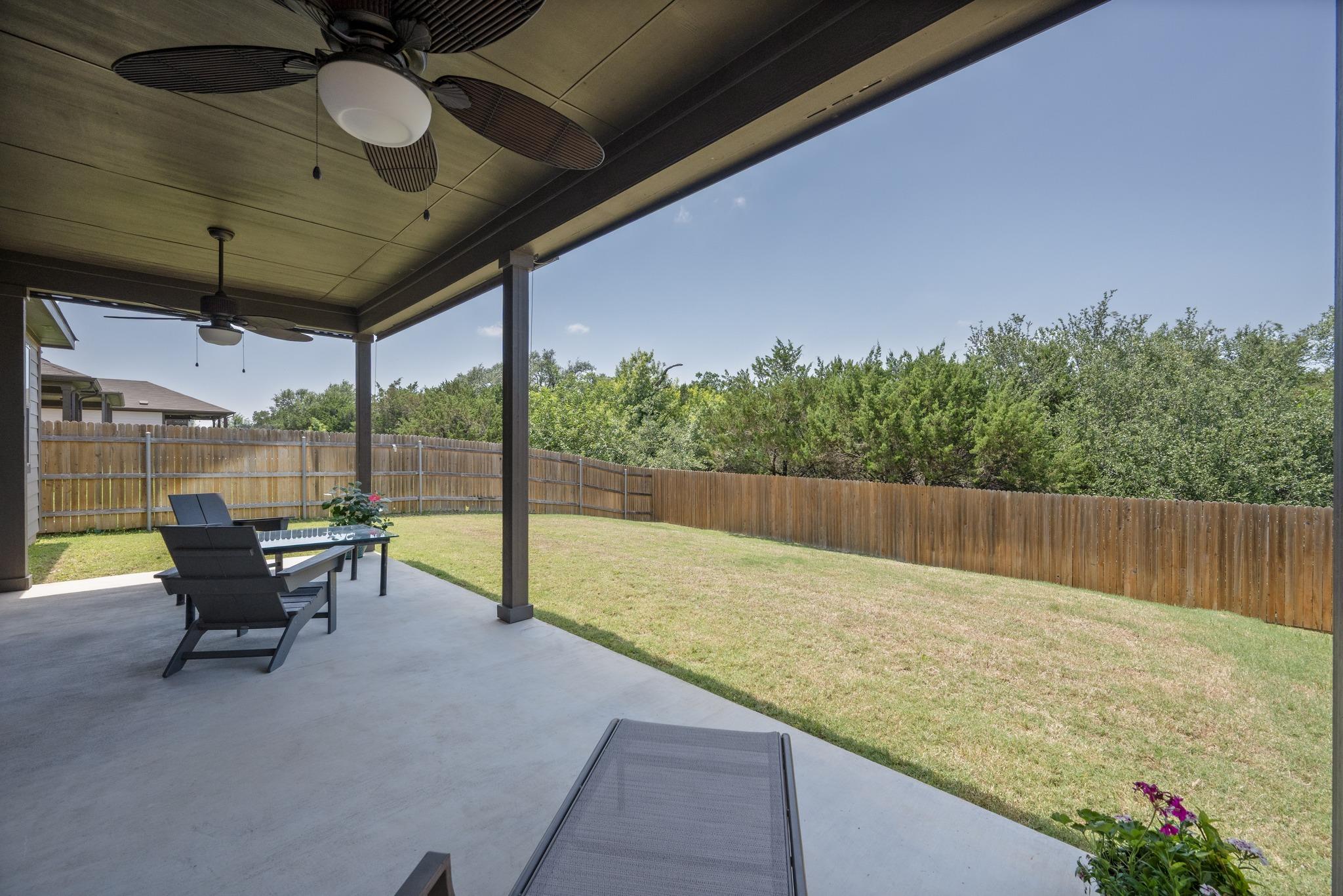 A spacious covered patio overlooks a private, fen