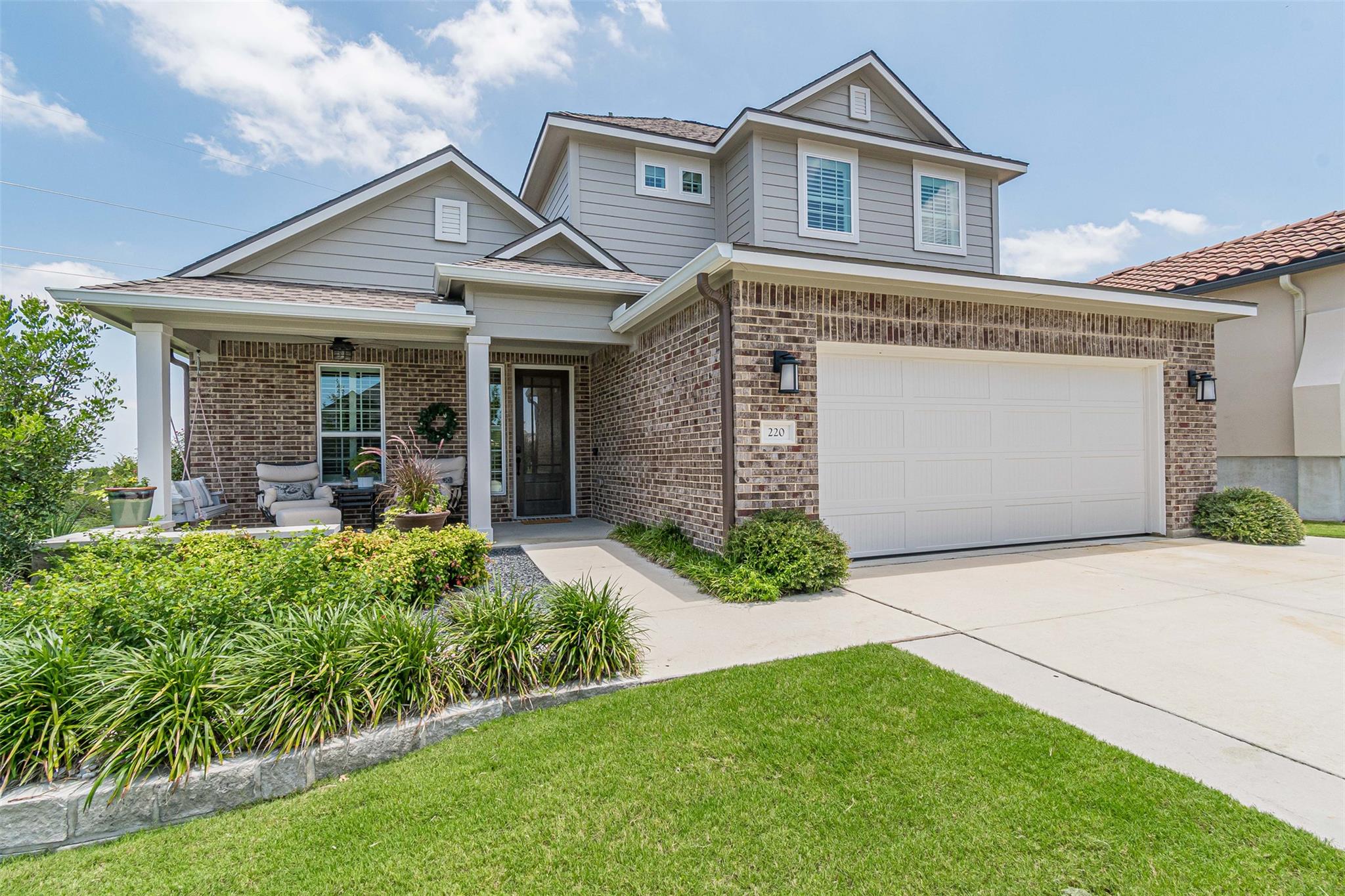 A welcoming brick and siding home features a cove