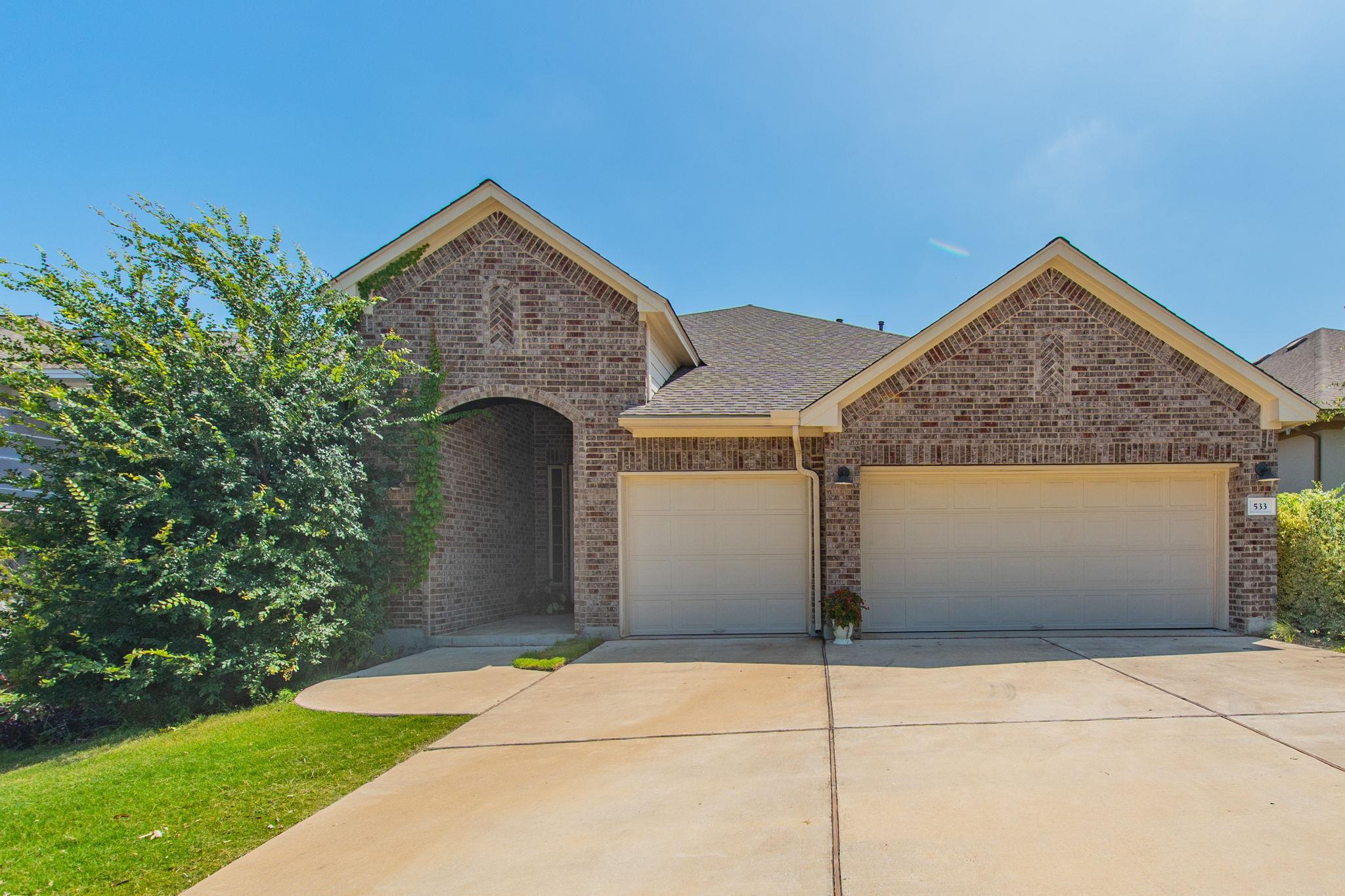 A classic brick exterior with dual garage doors a