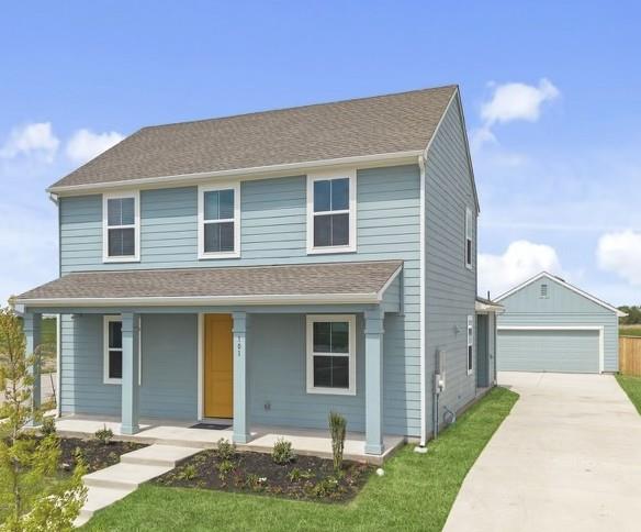 A welcoming front porch and detached garage compl