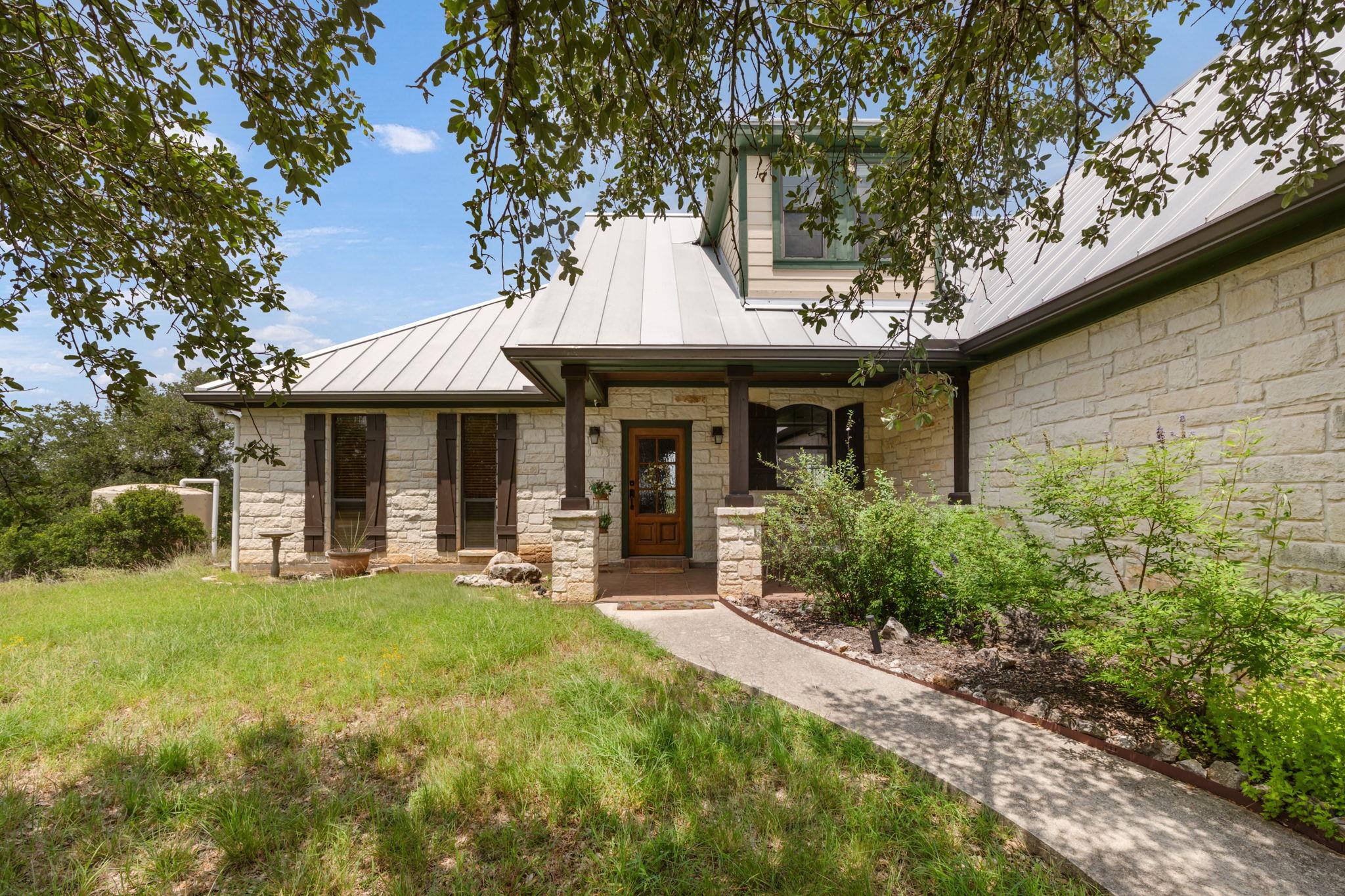 A striking stone facade with a metal roof and wel