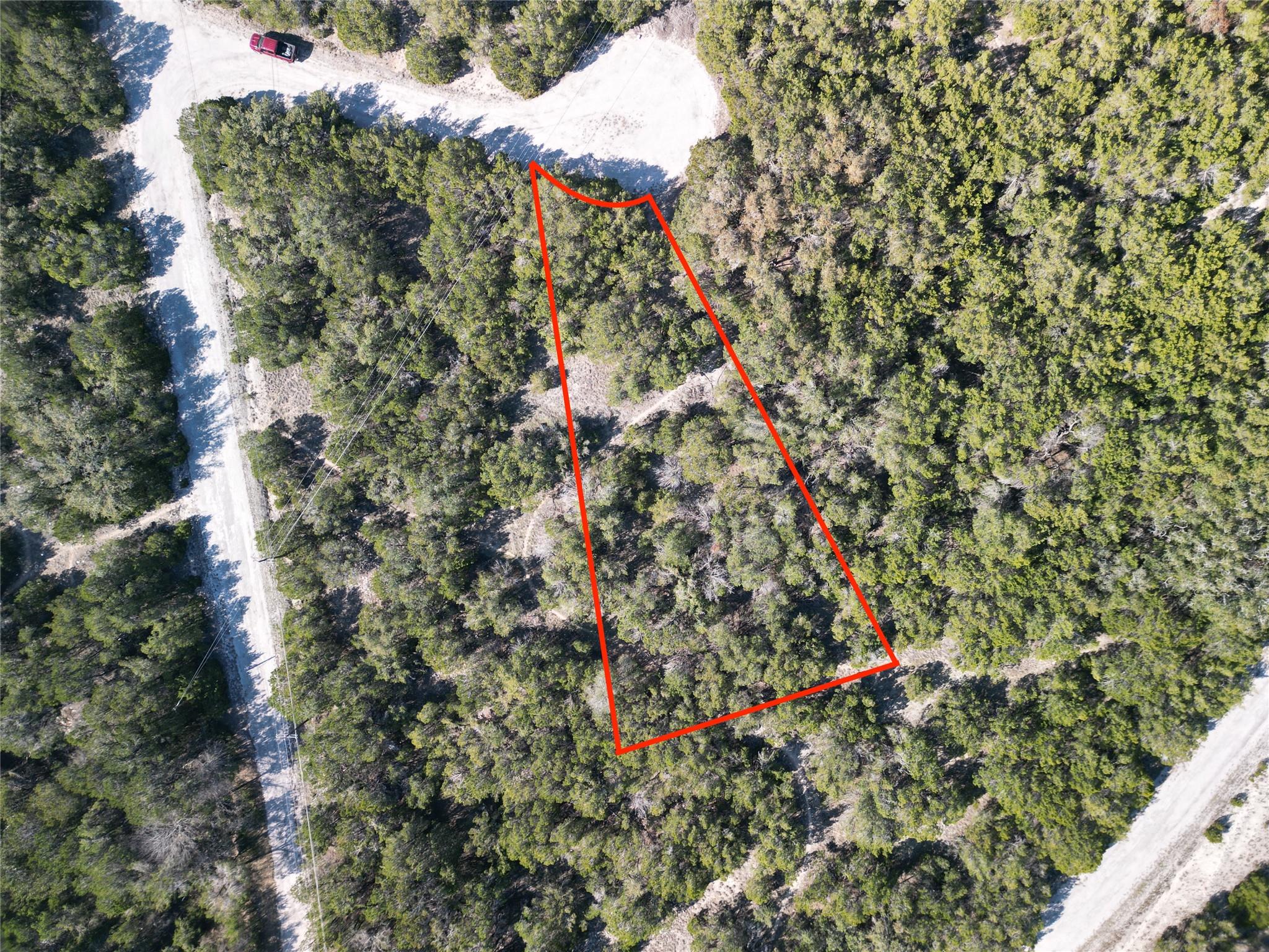 A spacious, tree-covered lot outlined in red, off