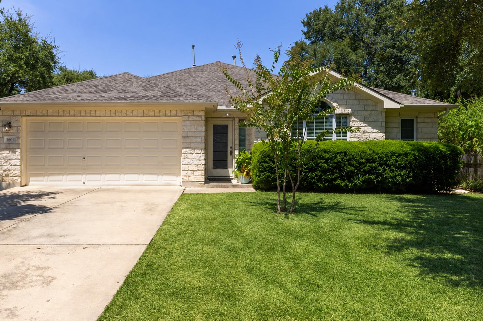 Limestone masonry and a neat lawn frame this clas