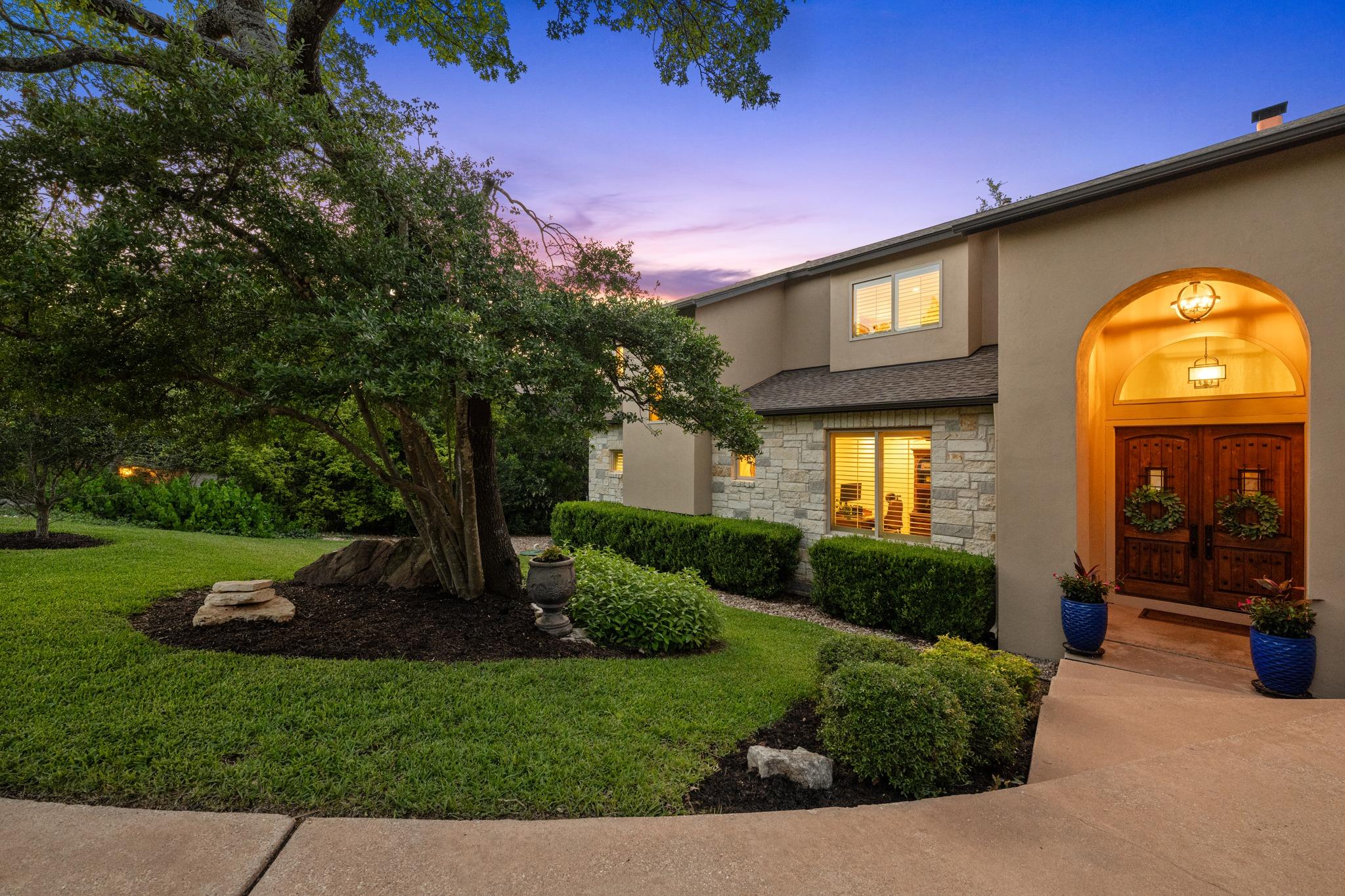 An inviting entry framed by mature trees and mani