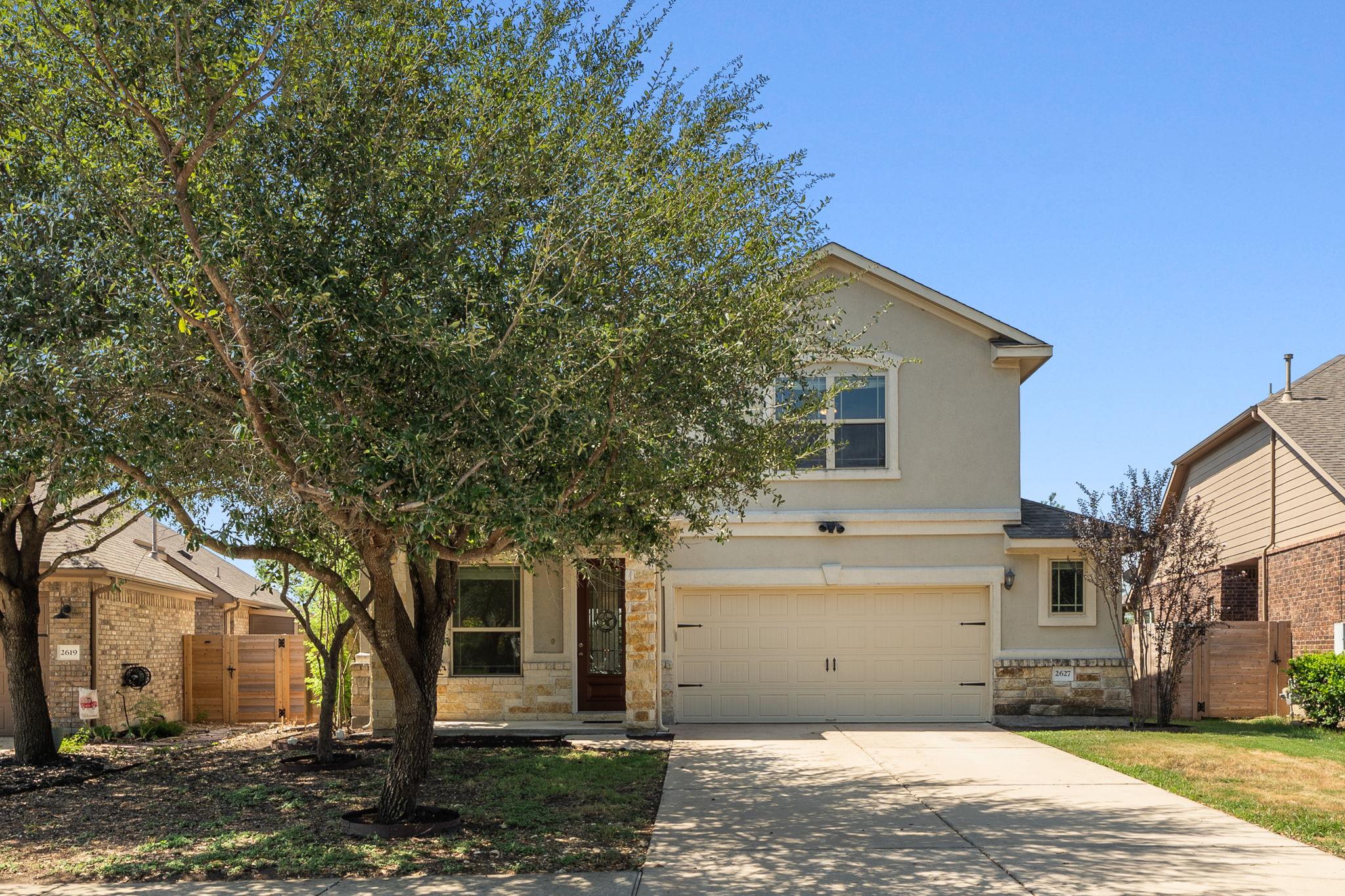 Mature trees frame a welcoming facade complete wi
