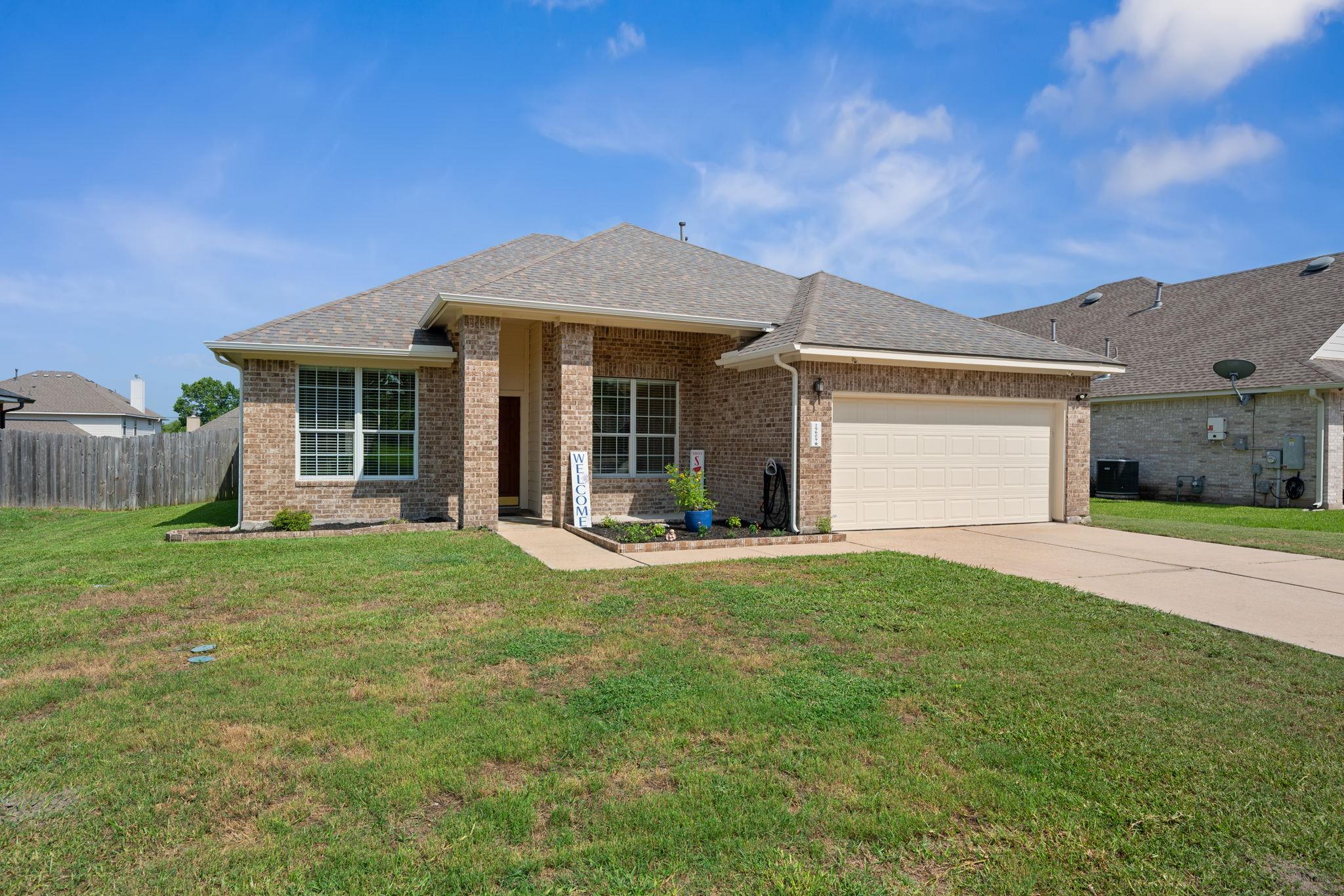 A classic brick exterior, inviting with a lush gr