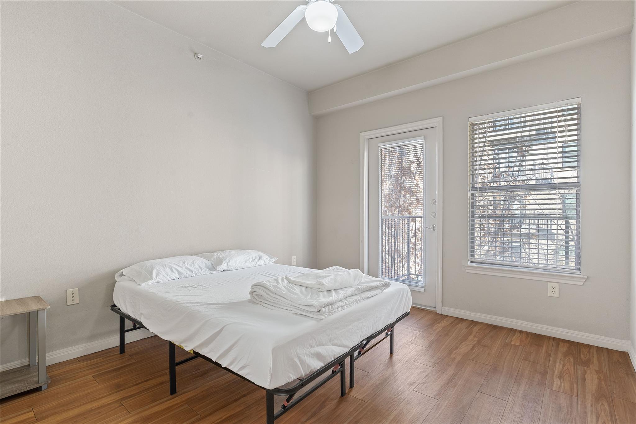 Bedroom with wood finished floors, access to exte