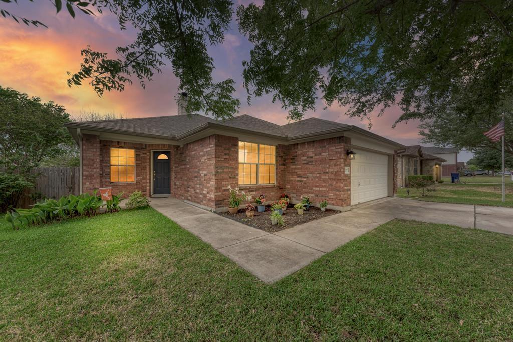 A well-maintained lawn and brick facade greet vis
